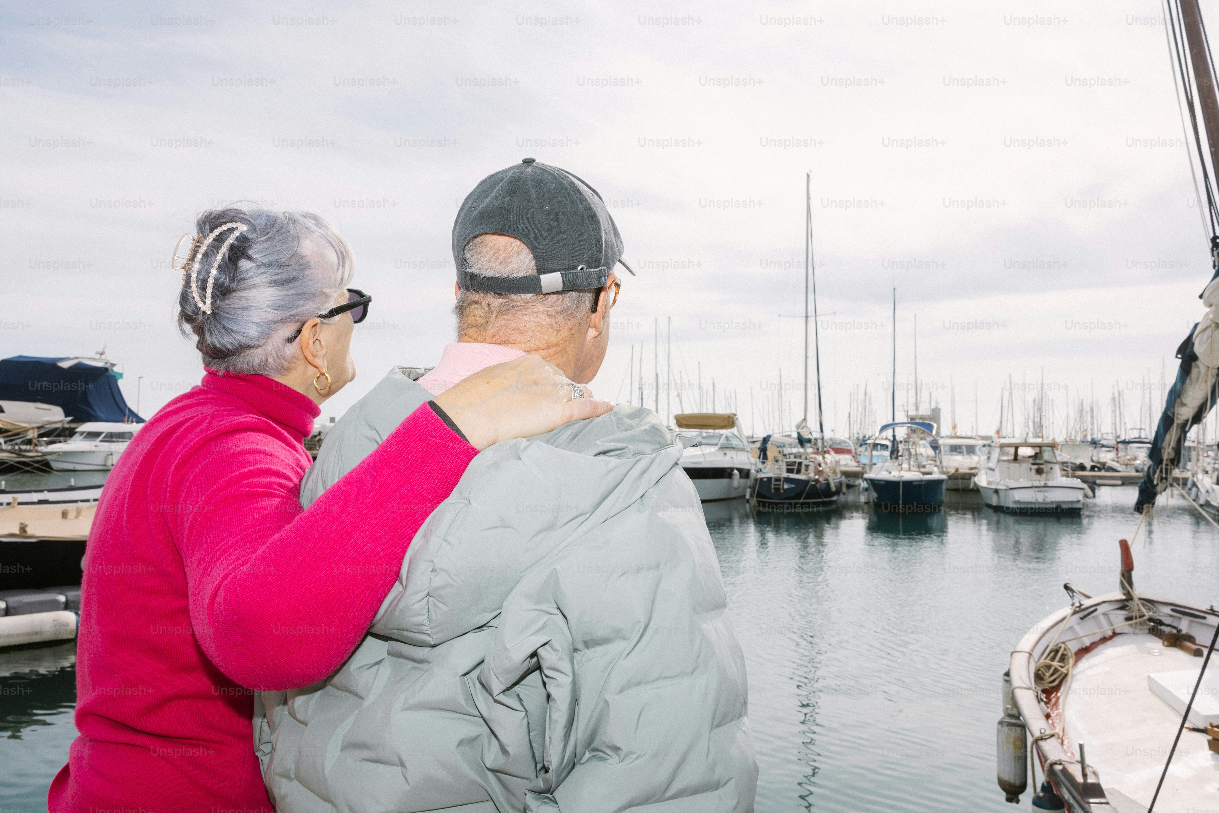 Casal idoso olhando barcos em um porto