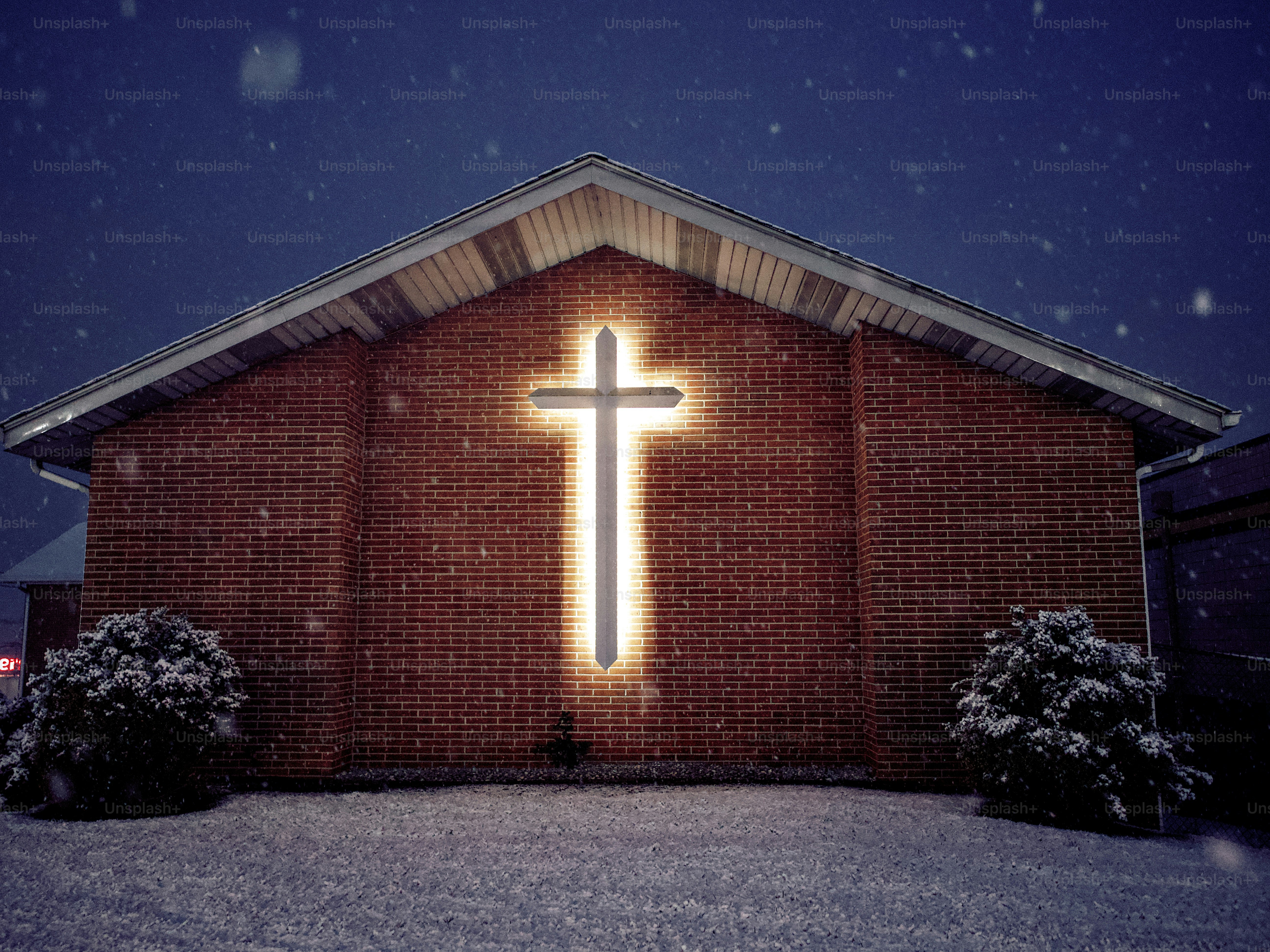 Glowing cross on brick building in snow