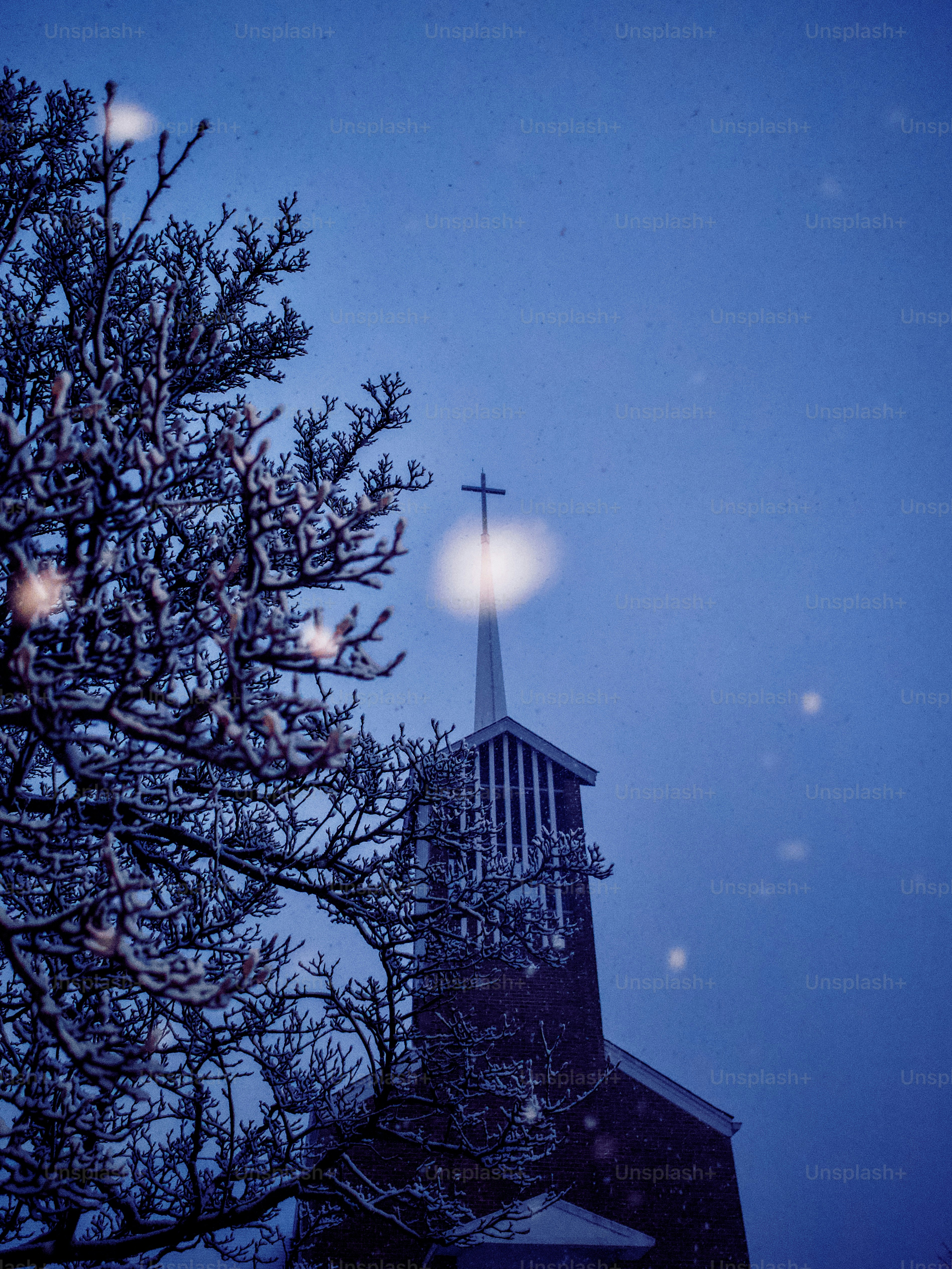 Church steeple with cross against a snowy sky