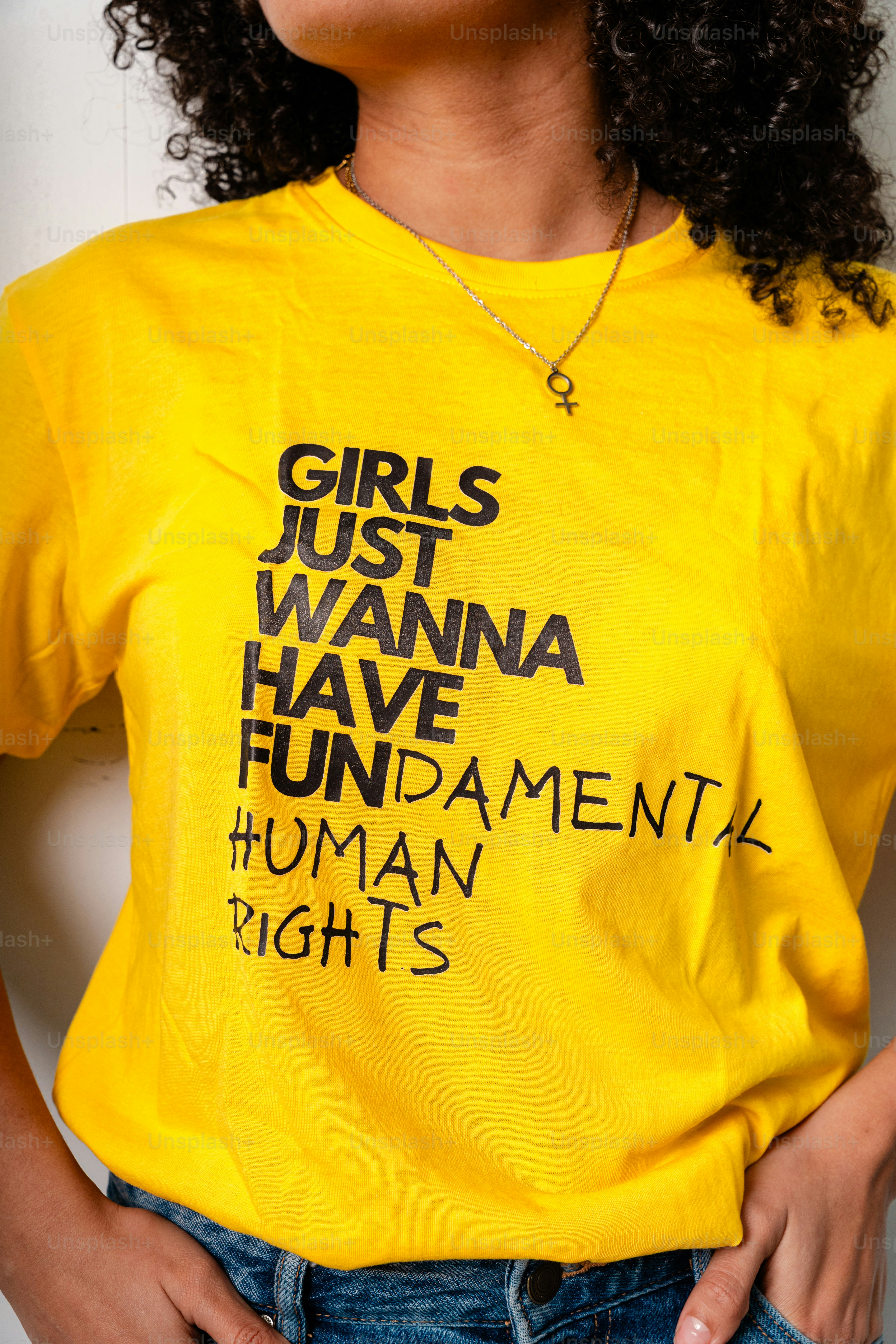 Woman wears yellow t-shirt with feminist slogan