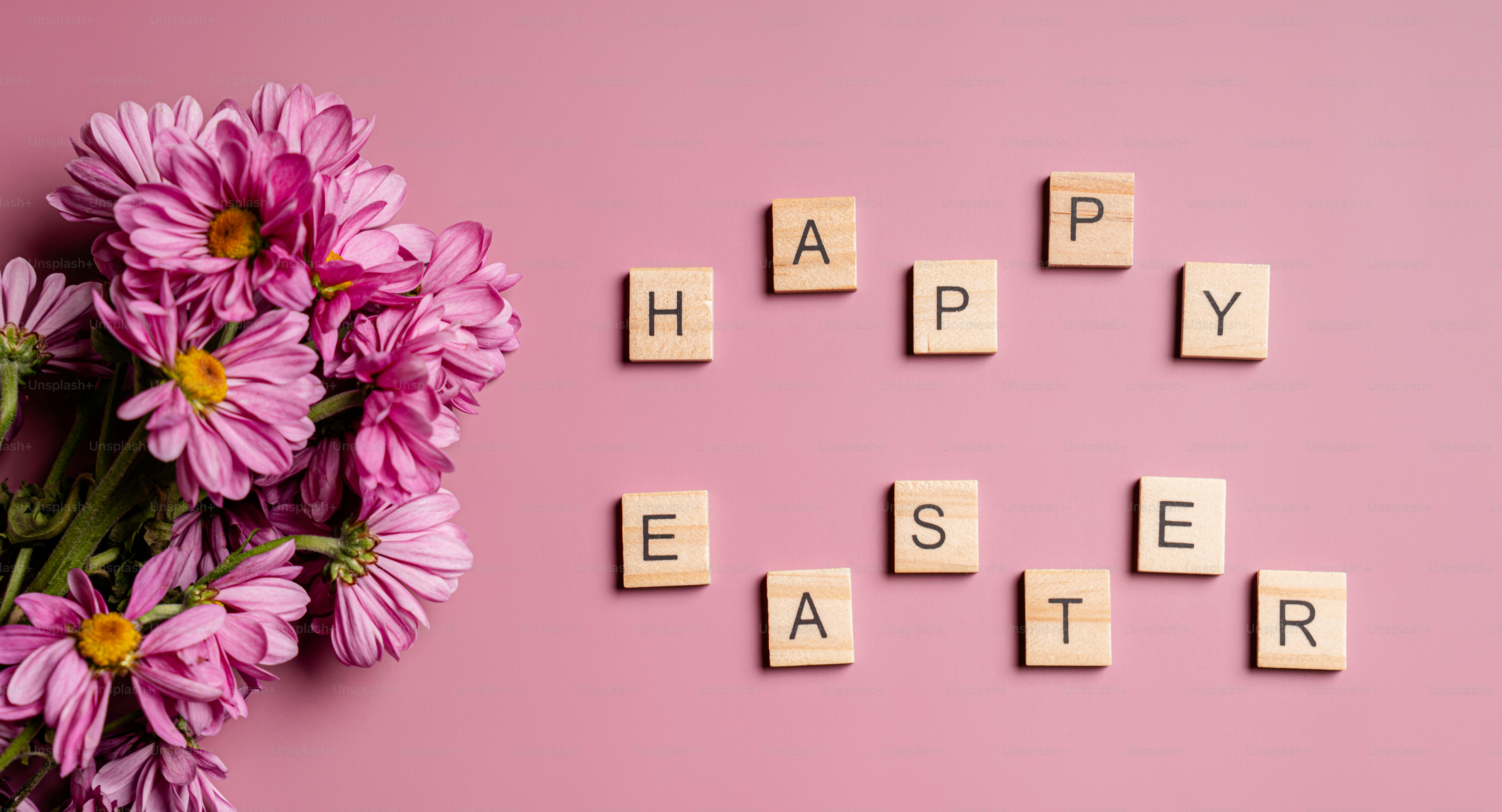 분홍색 꽃과 스크래블 타일이 해피 부활절을 상징합니다