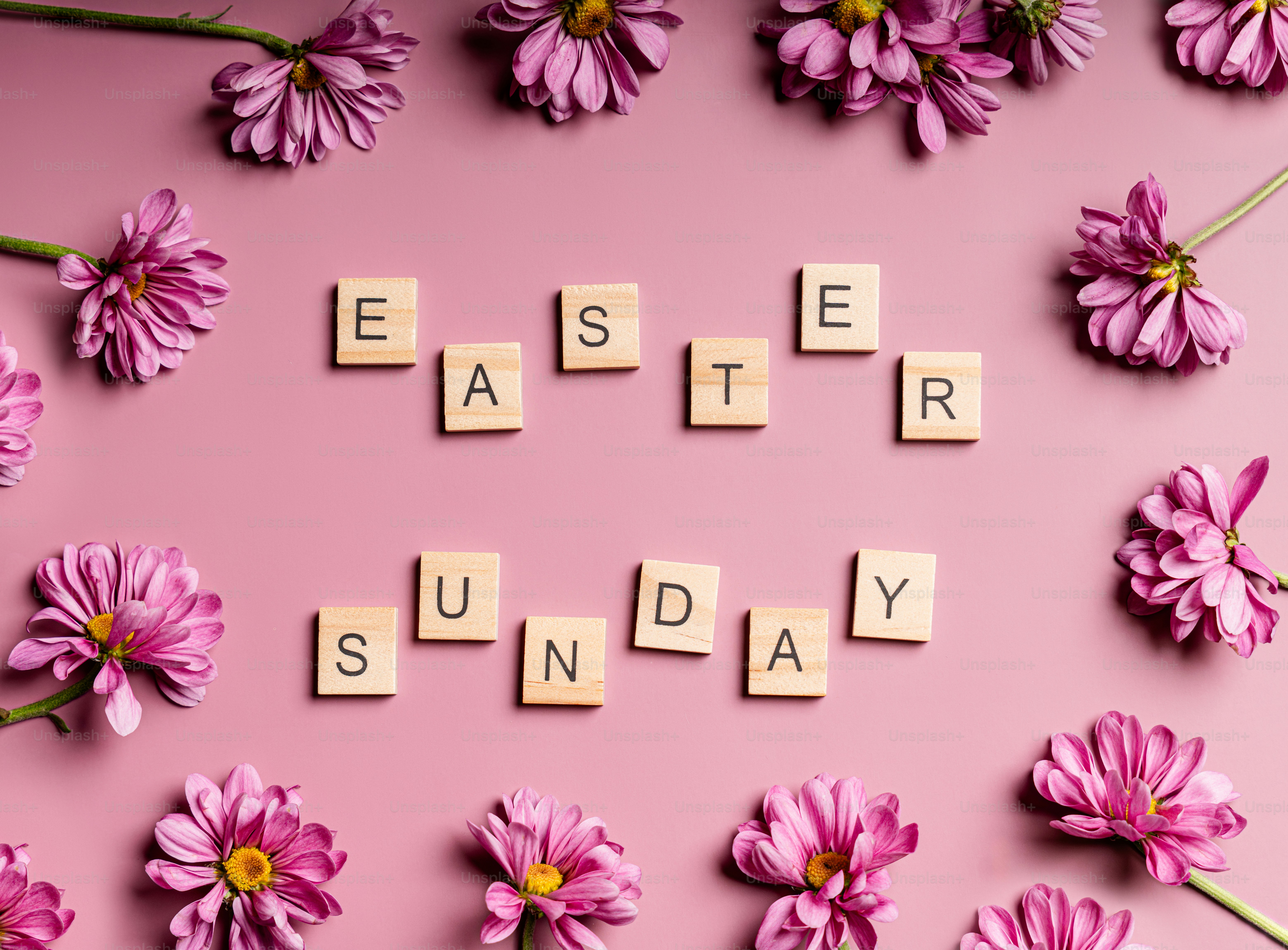Easter sunday spelled with scrabble tiles surrounded by flowers