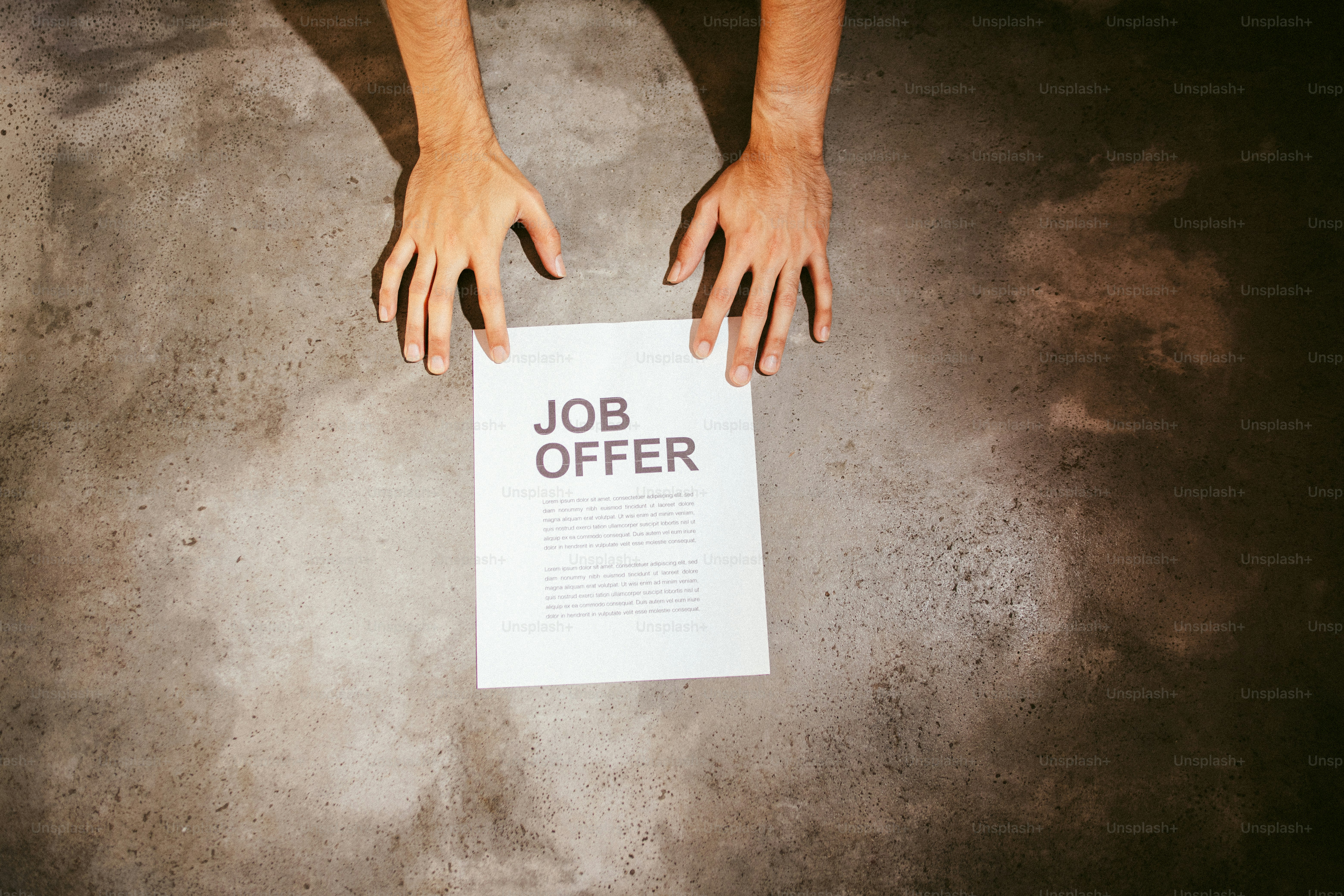 Hands reaching for a job offer document.