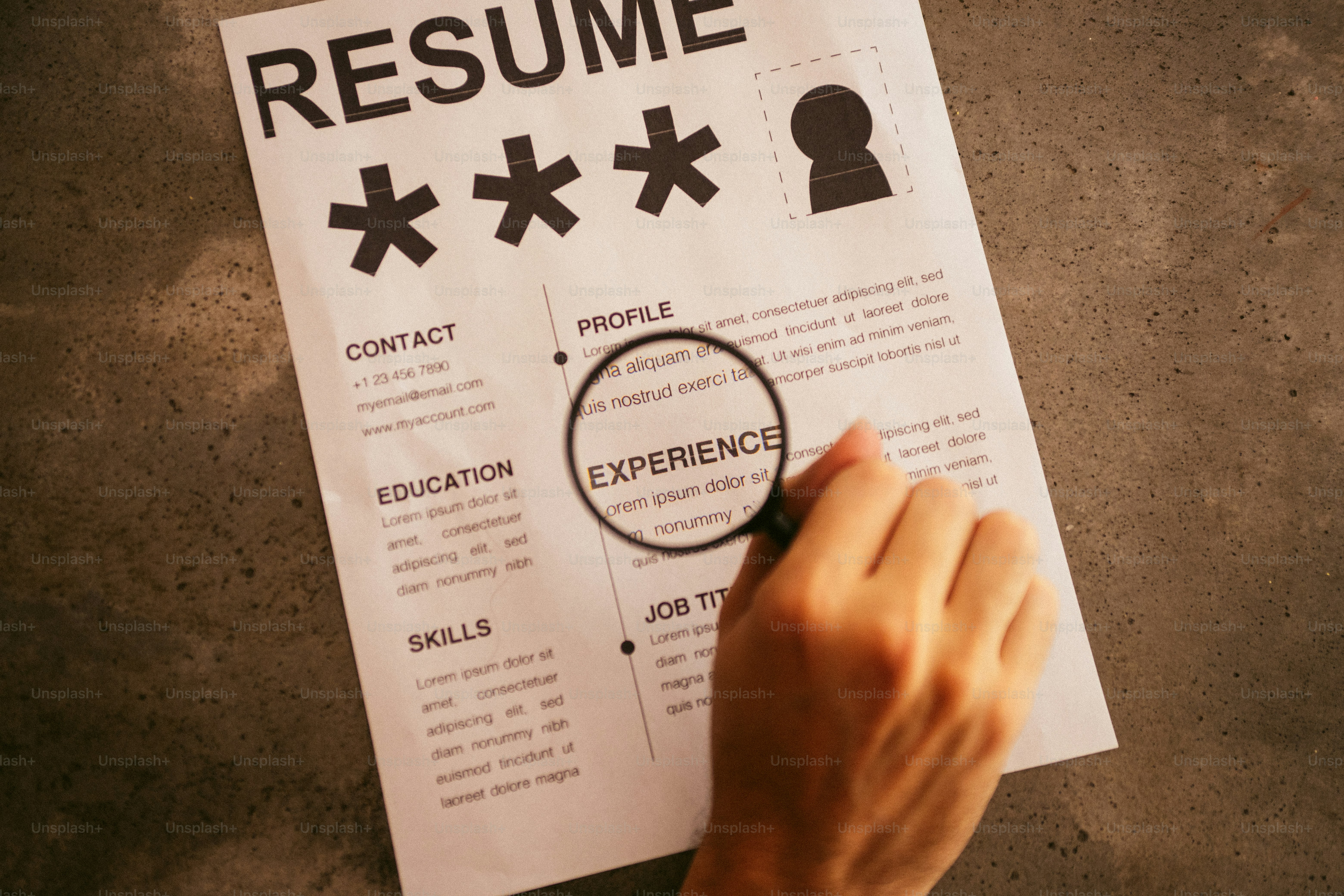 Magnifying glass over resume focusing on experience section.