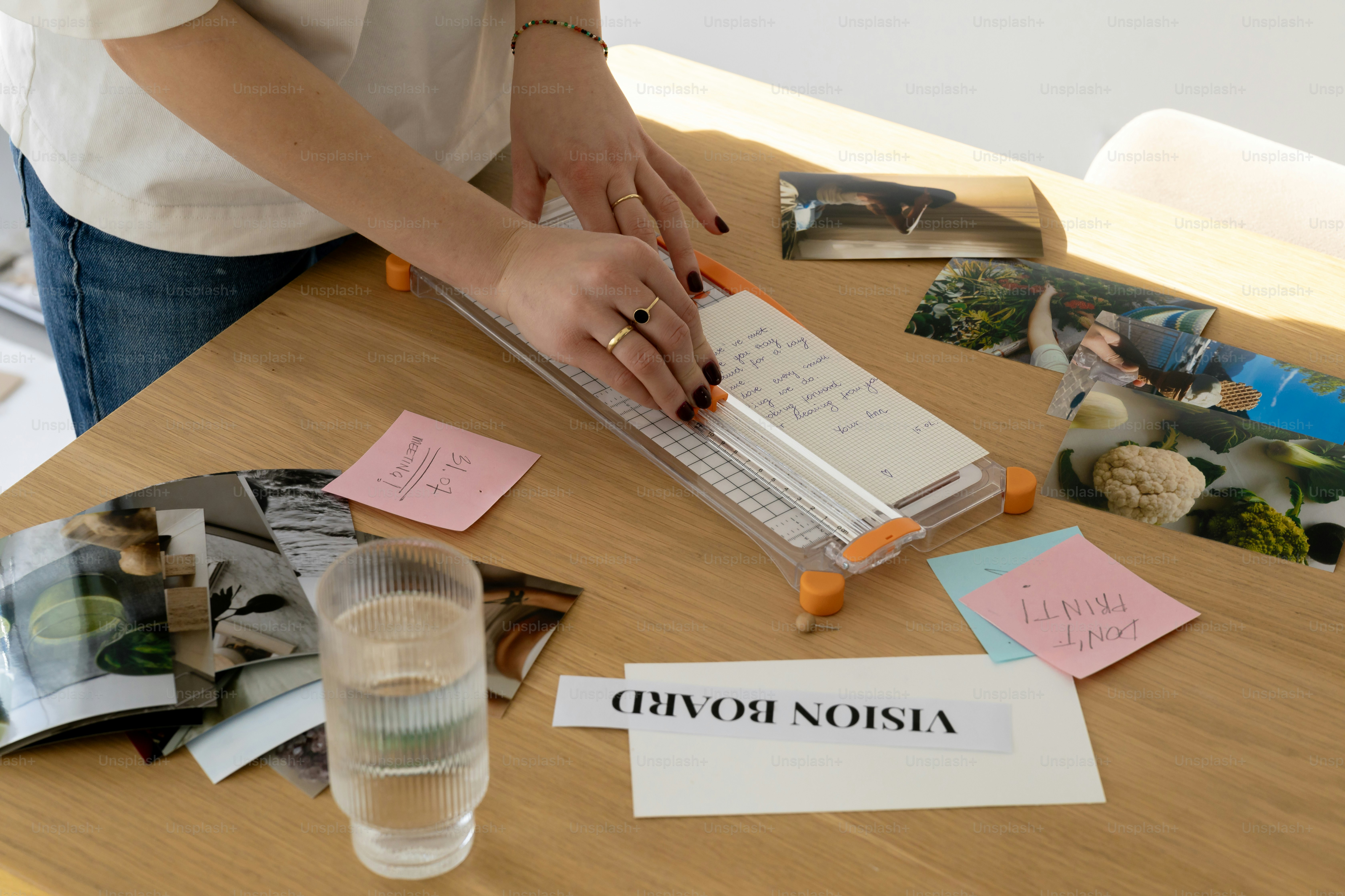 Woman cutting paper for vision board on table