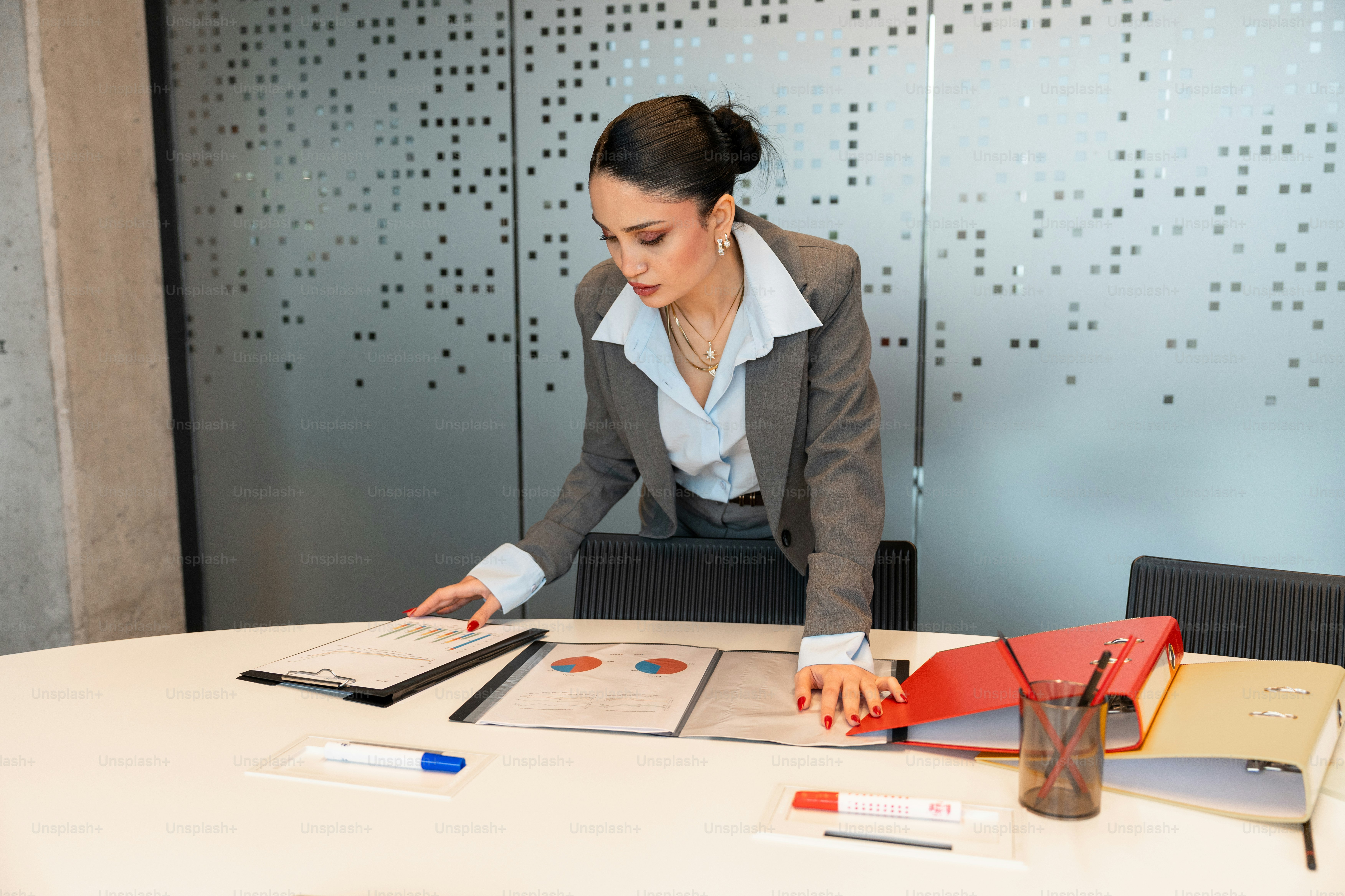 Businesswoman reviewing documents at a conference table.