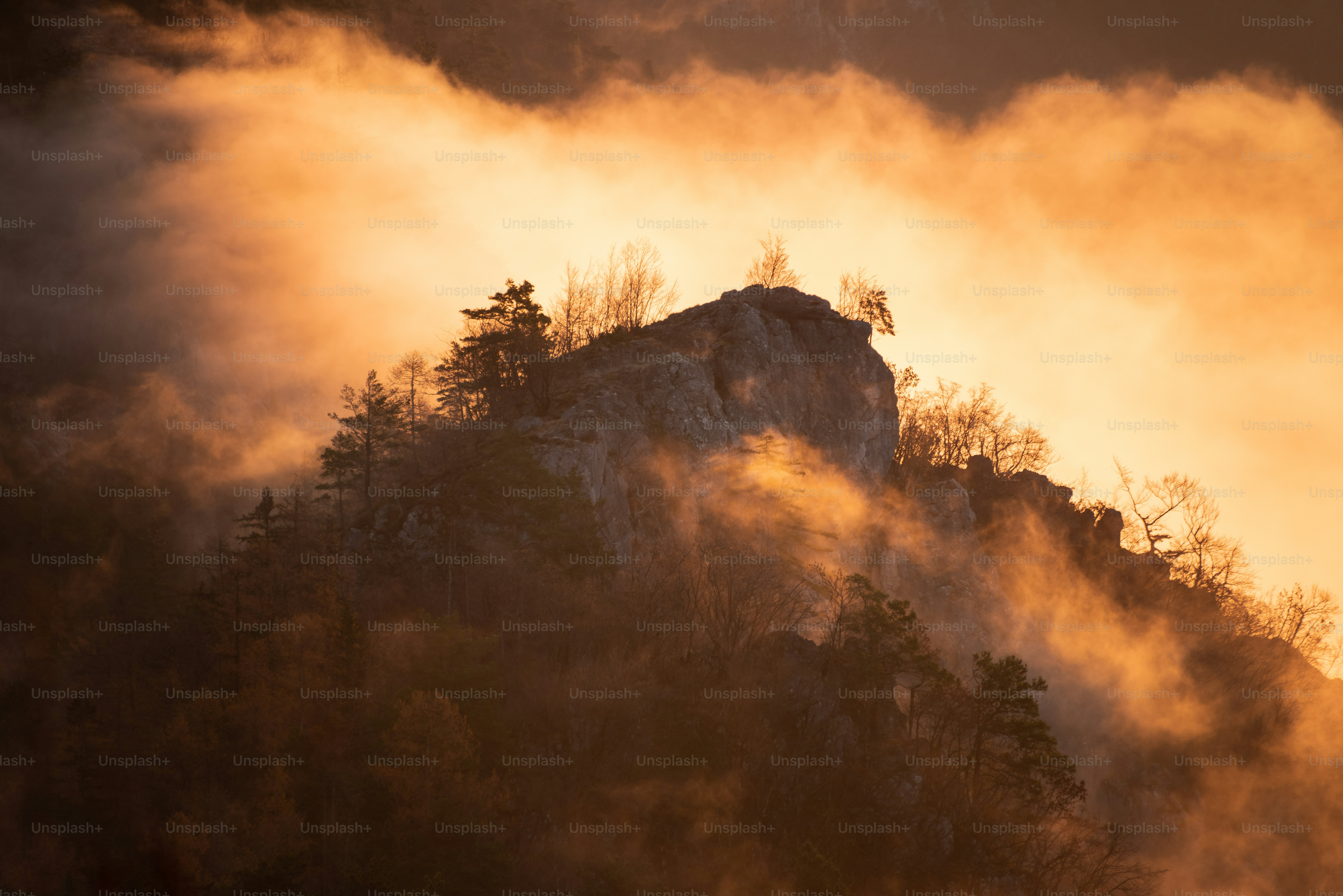 Misty mountain peak bathed in golden sunset light photo – Sunset Image ...