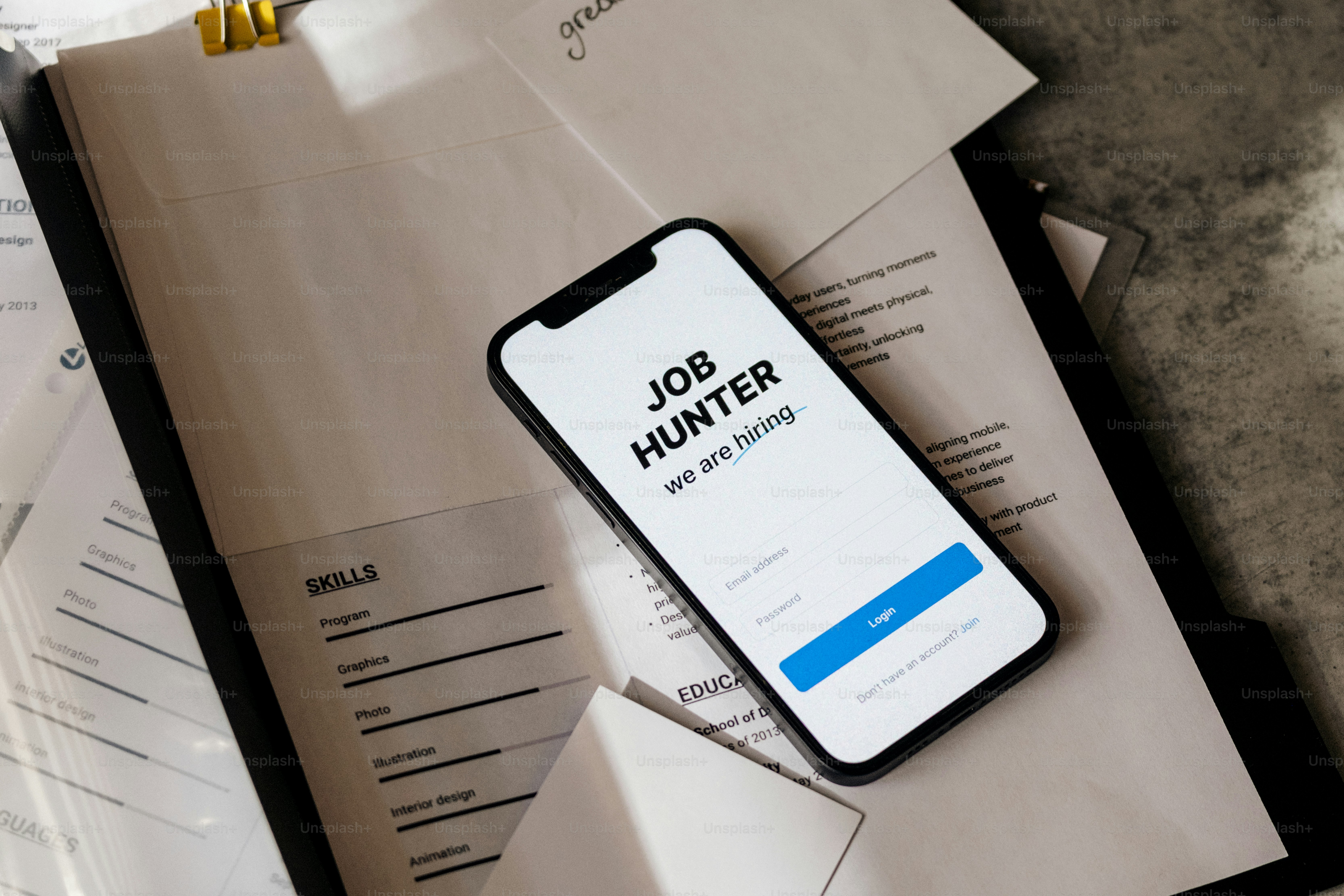 Smartphone menampilkan aplikasi "pemburu kerja" dengan resume.