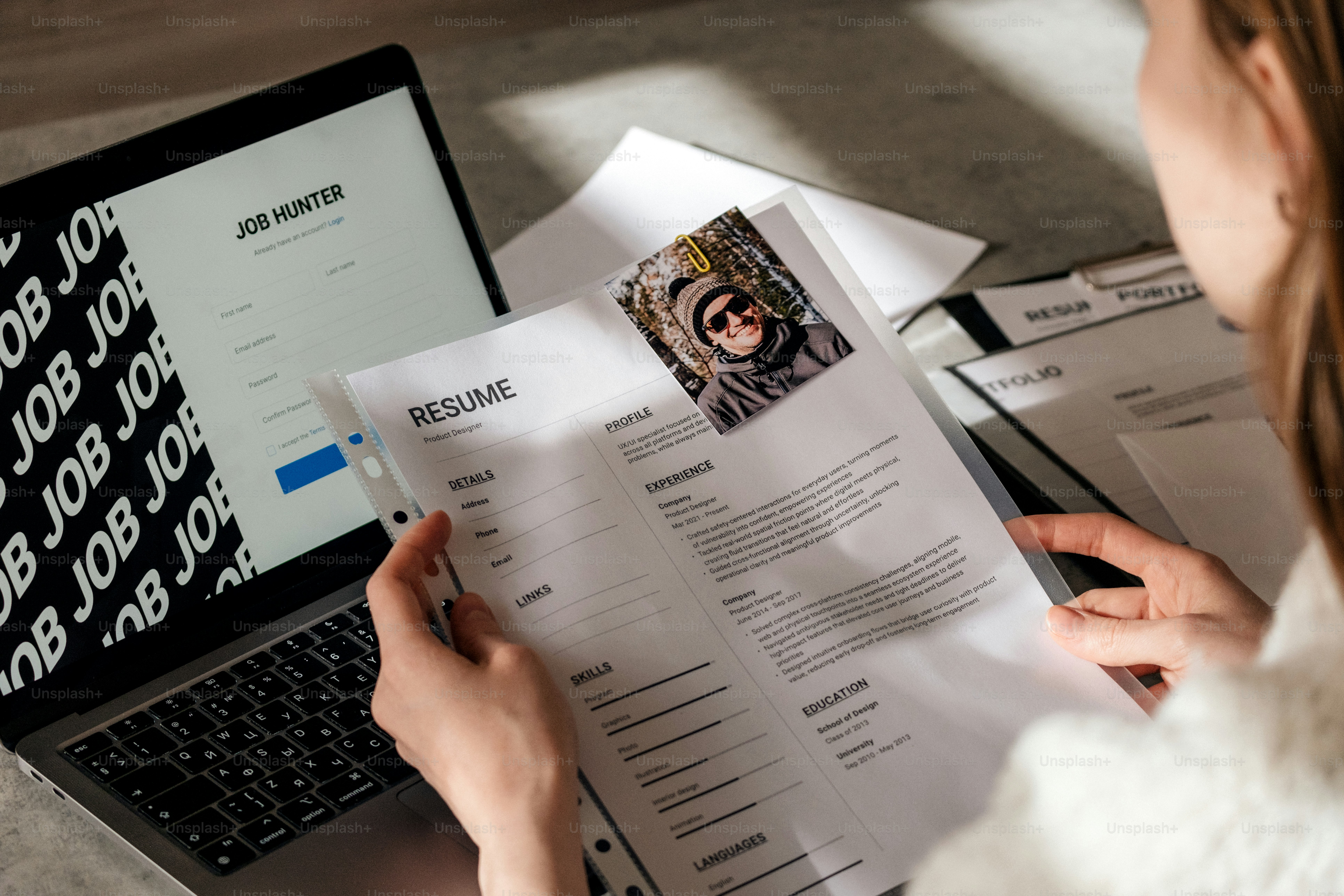 Person reviewing resume and laptop with laptop open