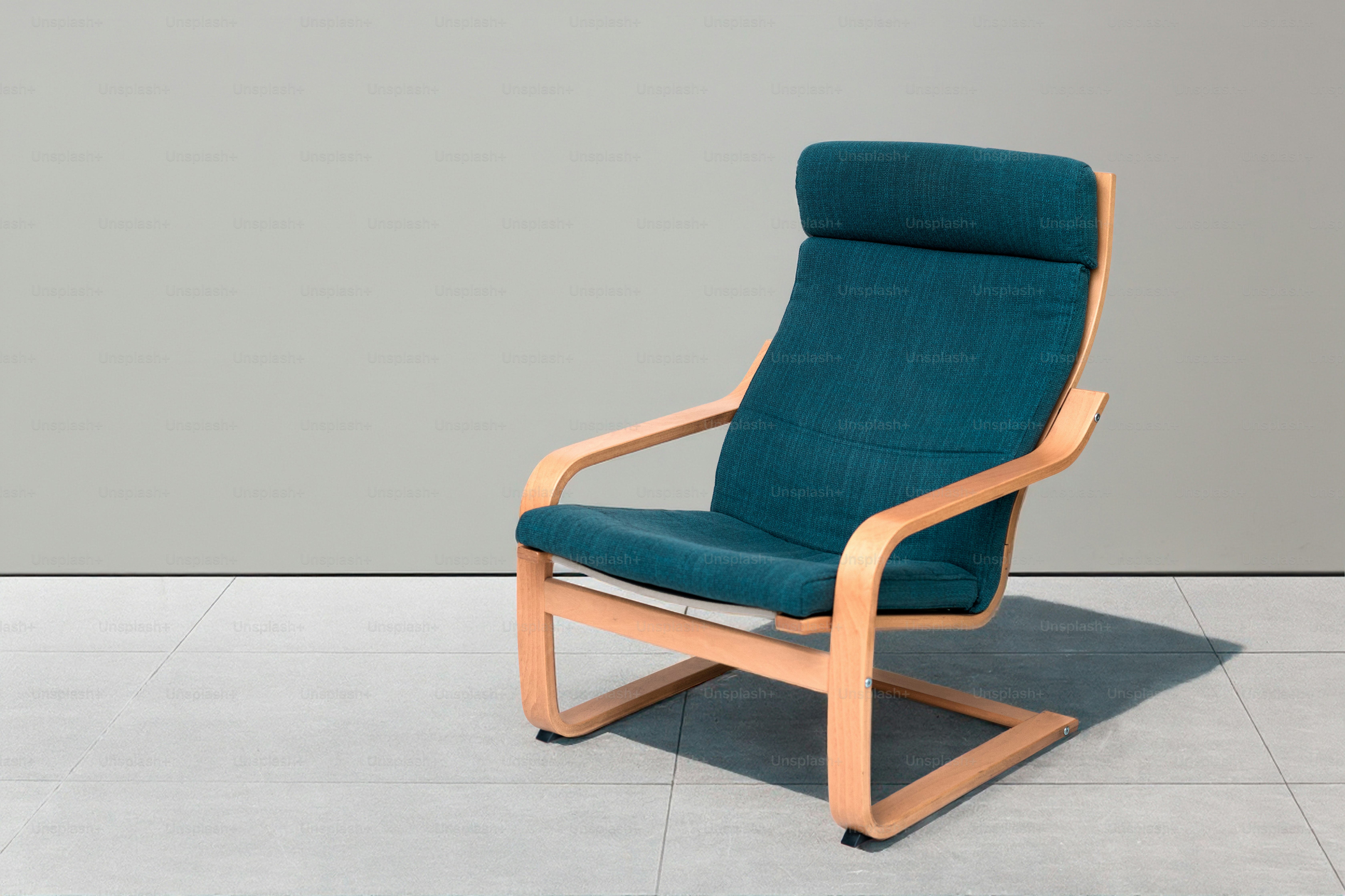 A teal armchair with a wooden frame
