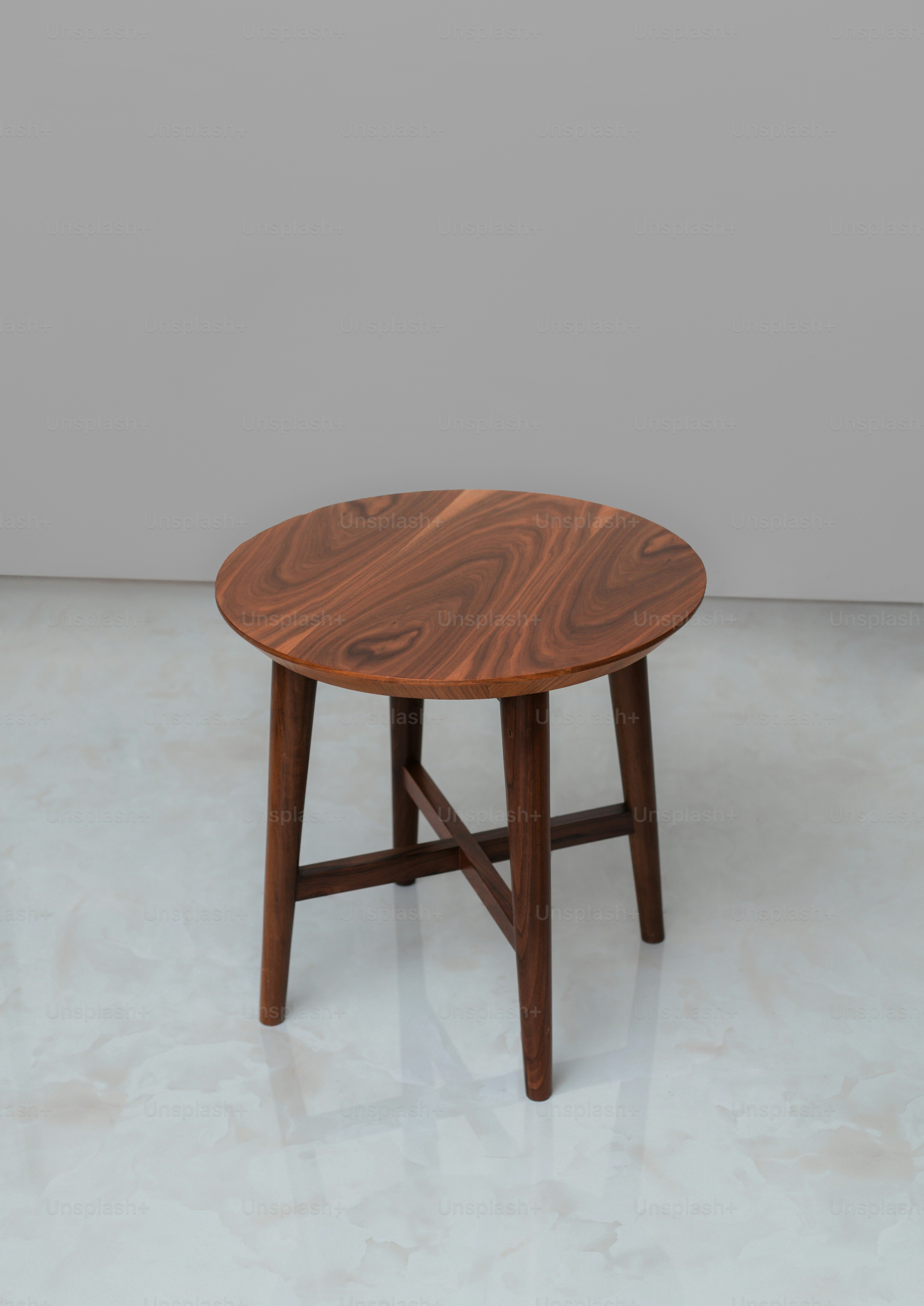 A round wooden side table with four legs