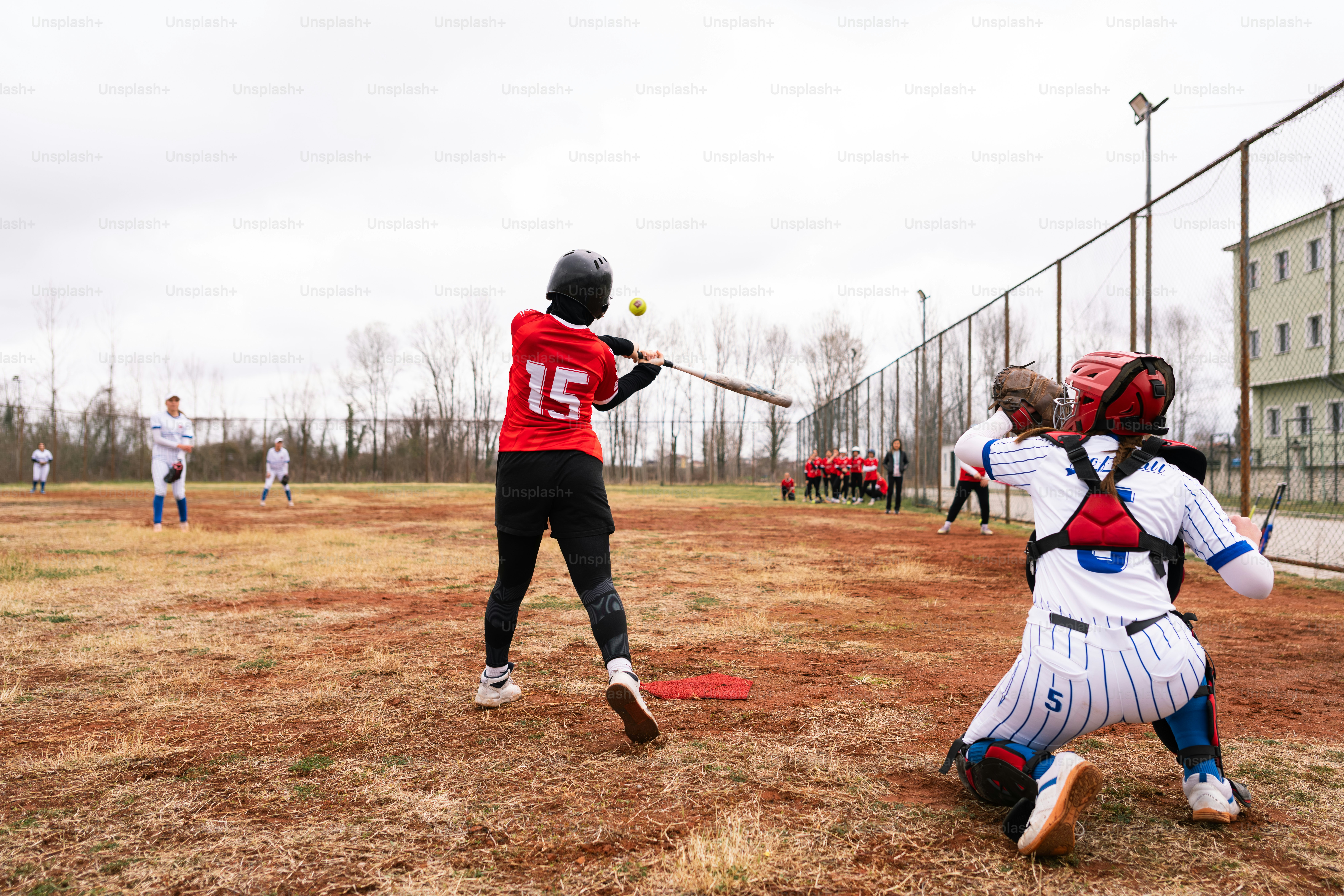 Un jugador de béisbol batea a un lanzamiento con el receptor listo.