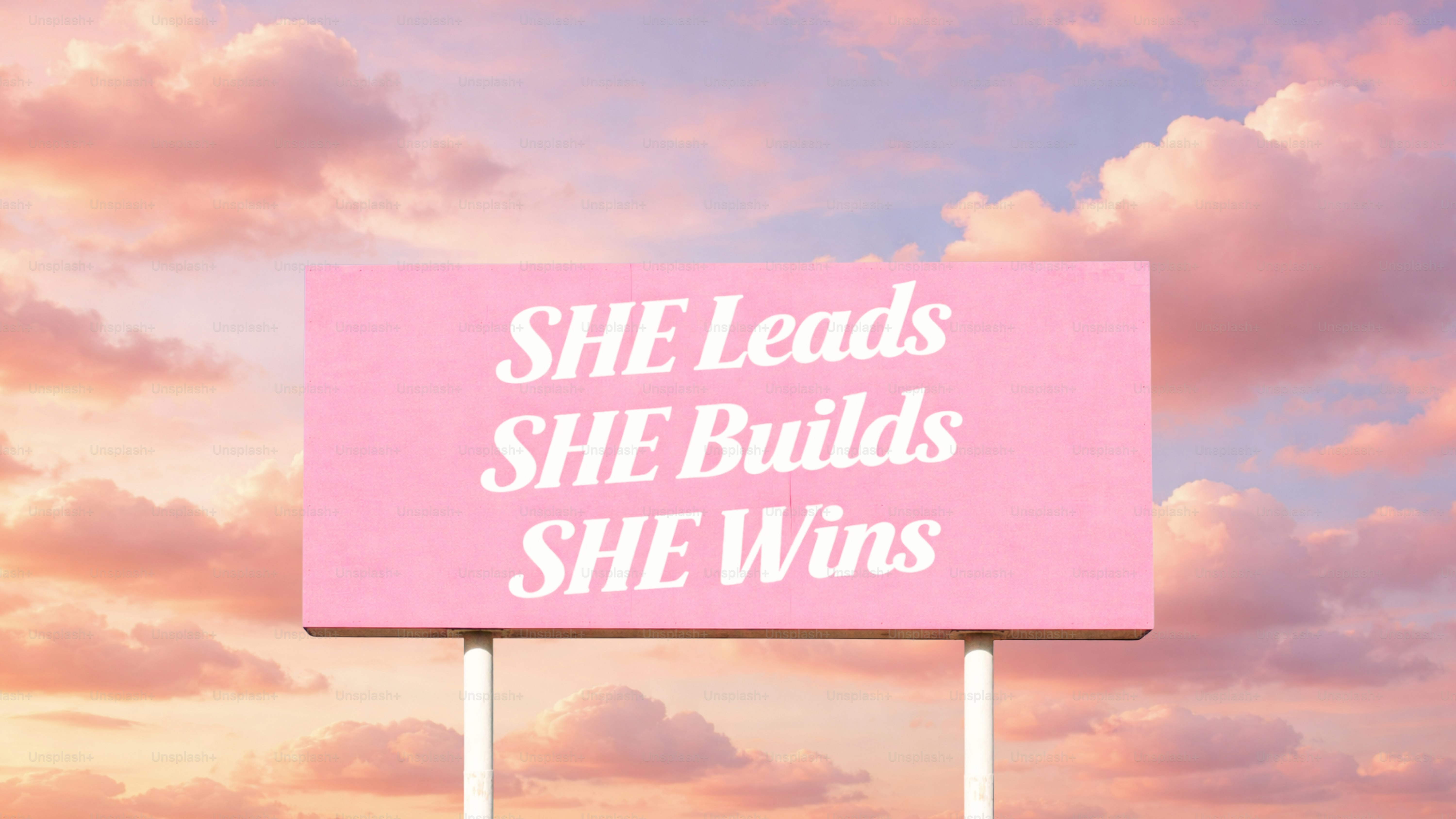 흐린 하늘을 배경으로 영감을 주는 글자가 적힌 분홍색 광고판