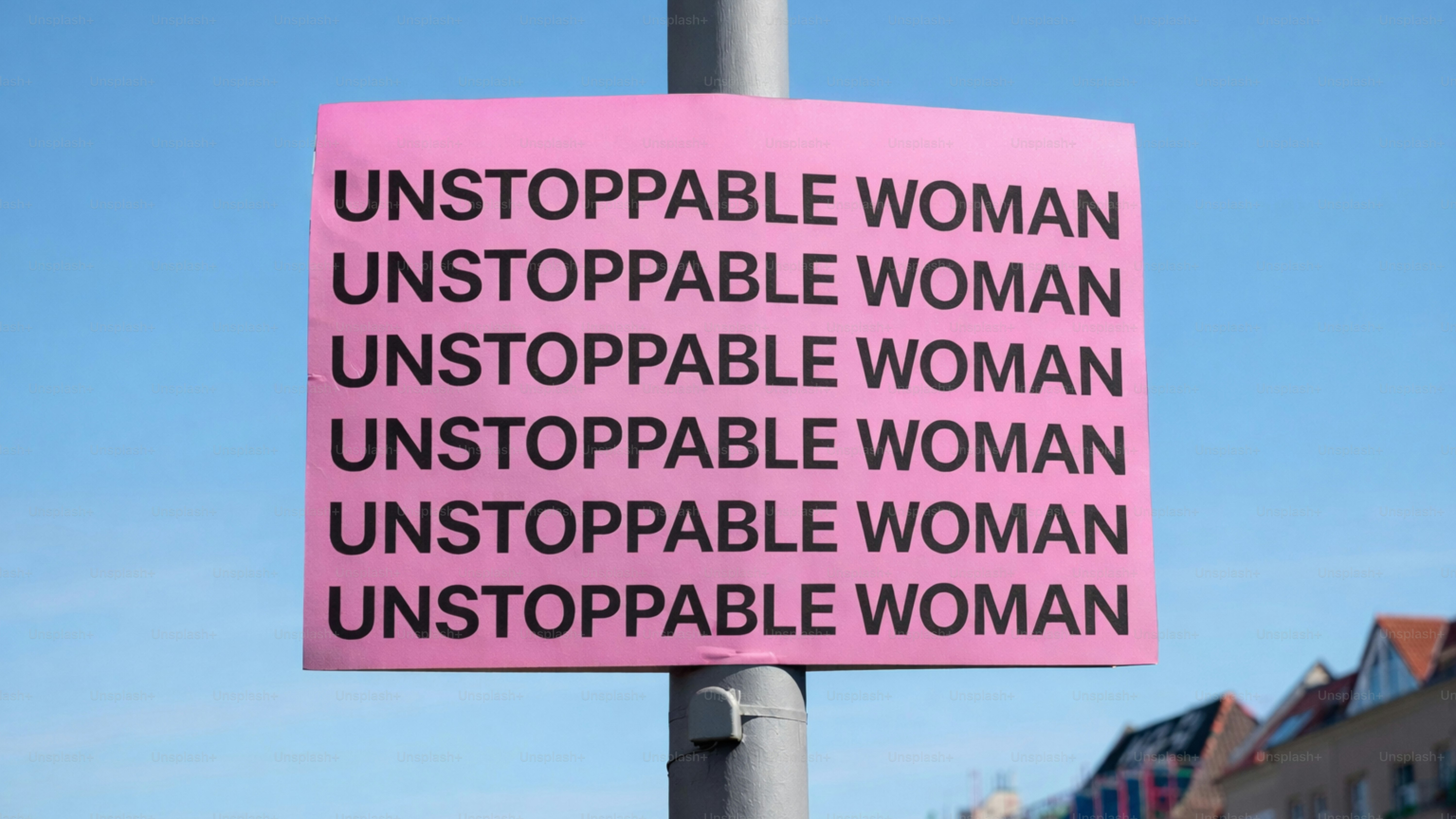 Cartello rosa con "donna inarrestabile" ripetuto