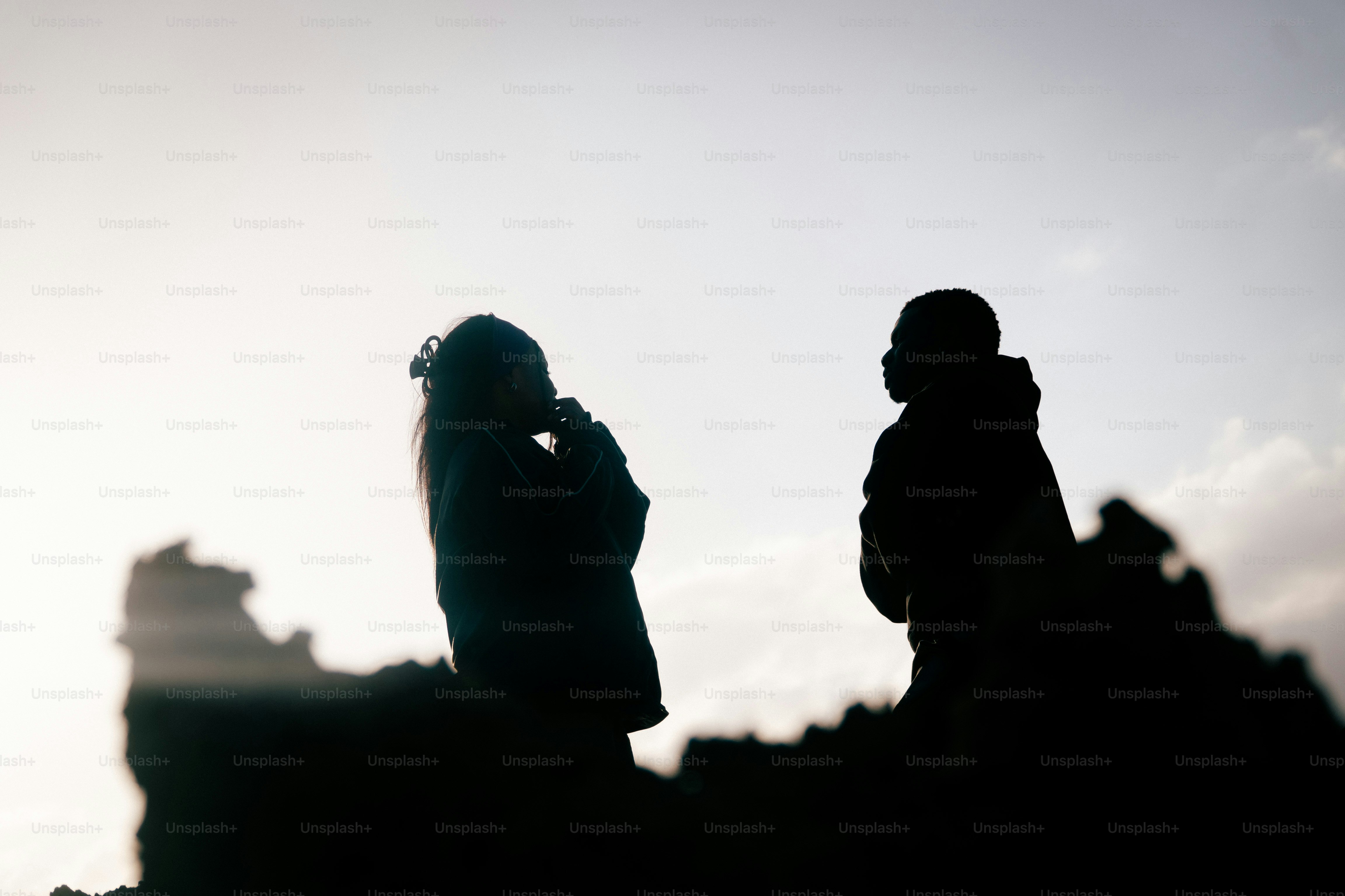 Dos personas recortadas contra un cielo brillante