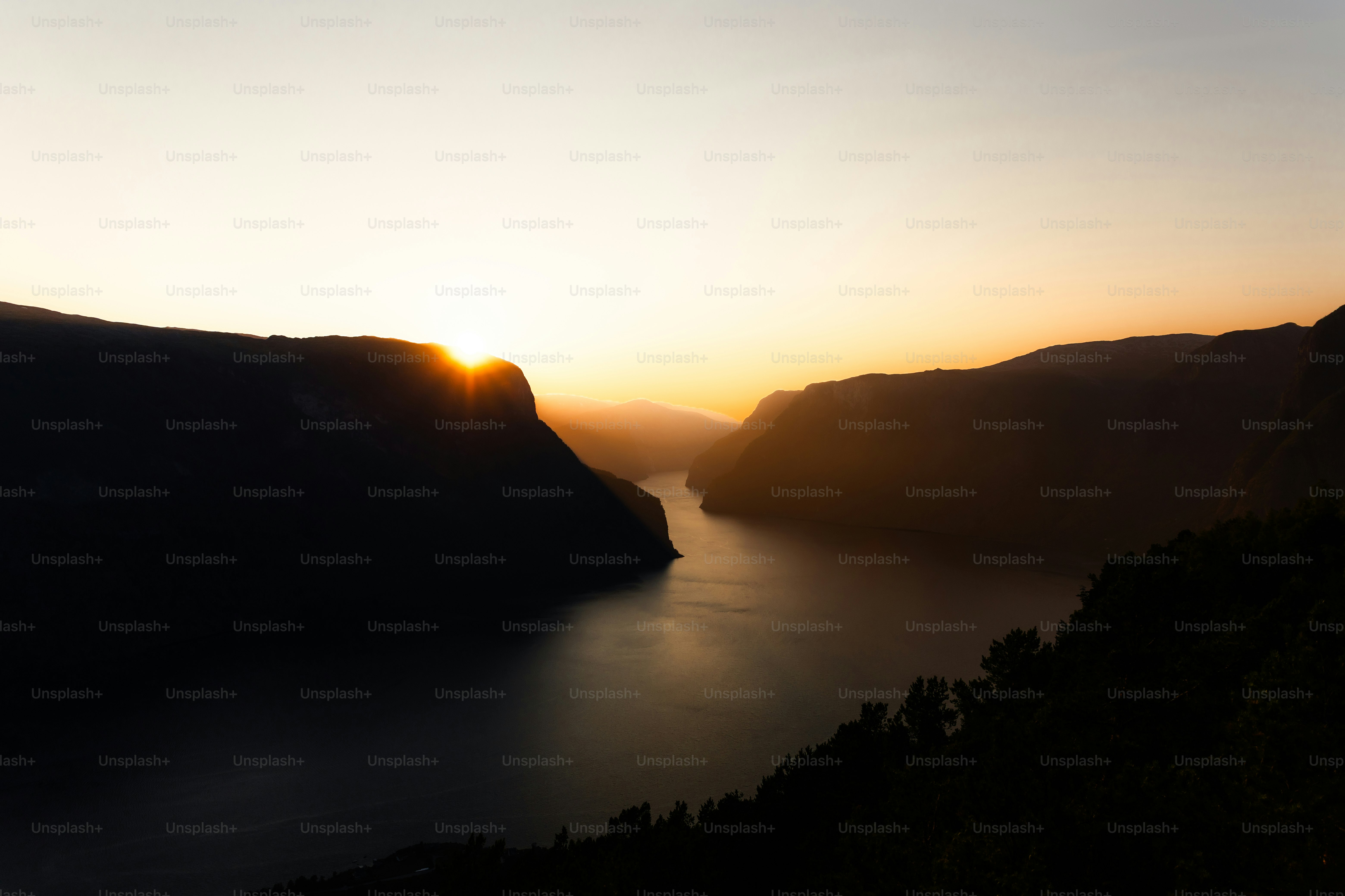 山々の間の穏やかな水面に夕焼け