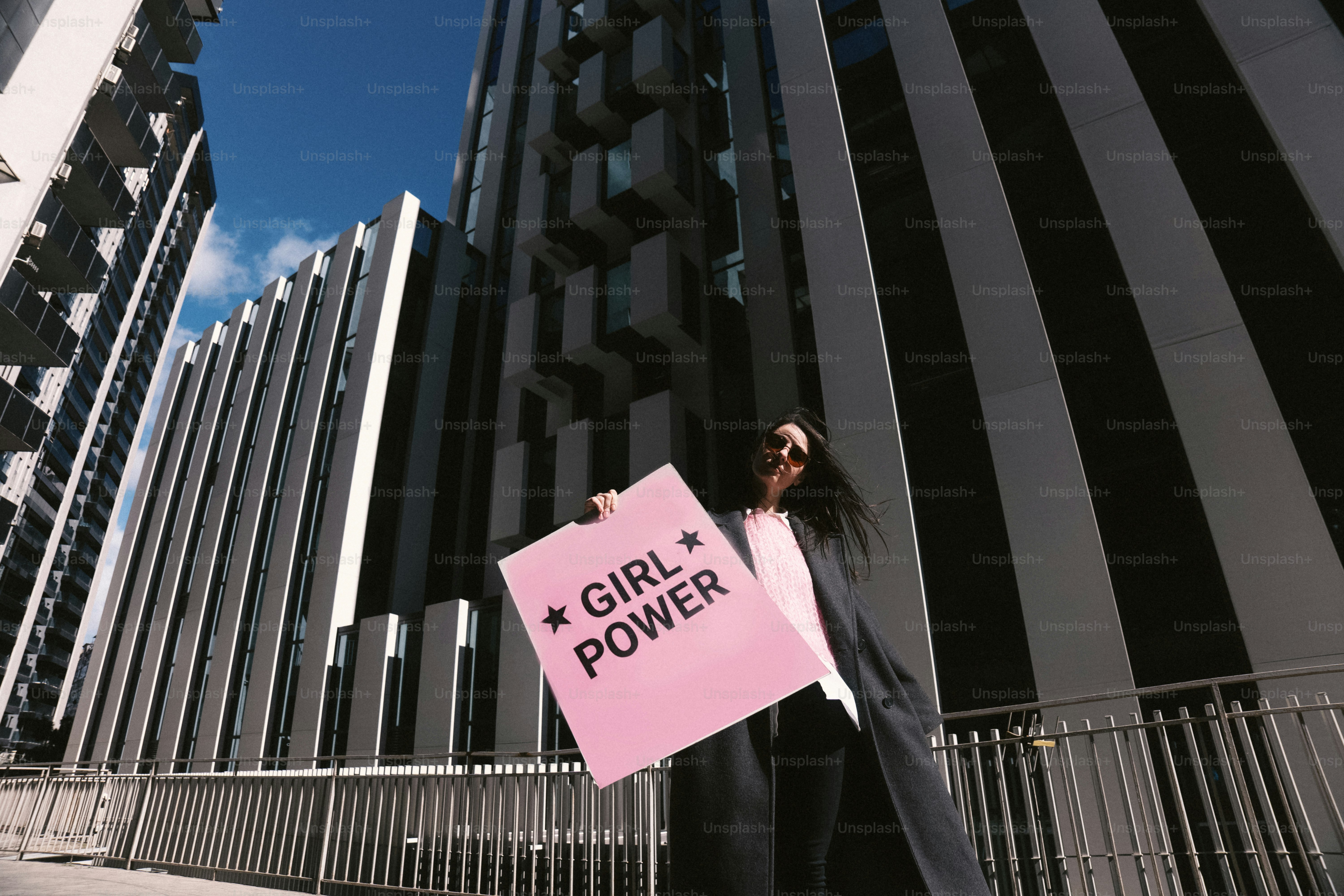 Woman holding a pink sign with "girl power"