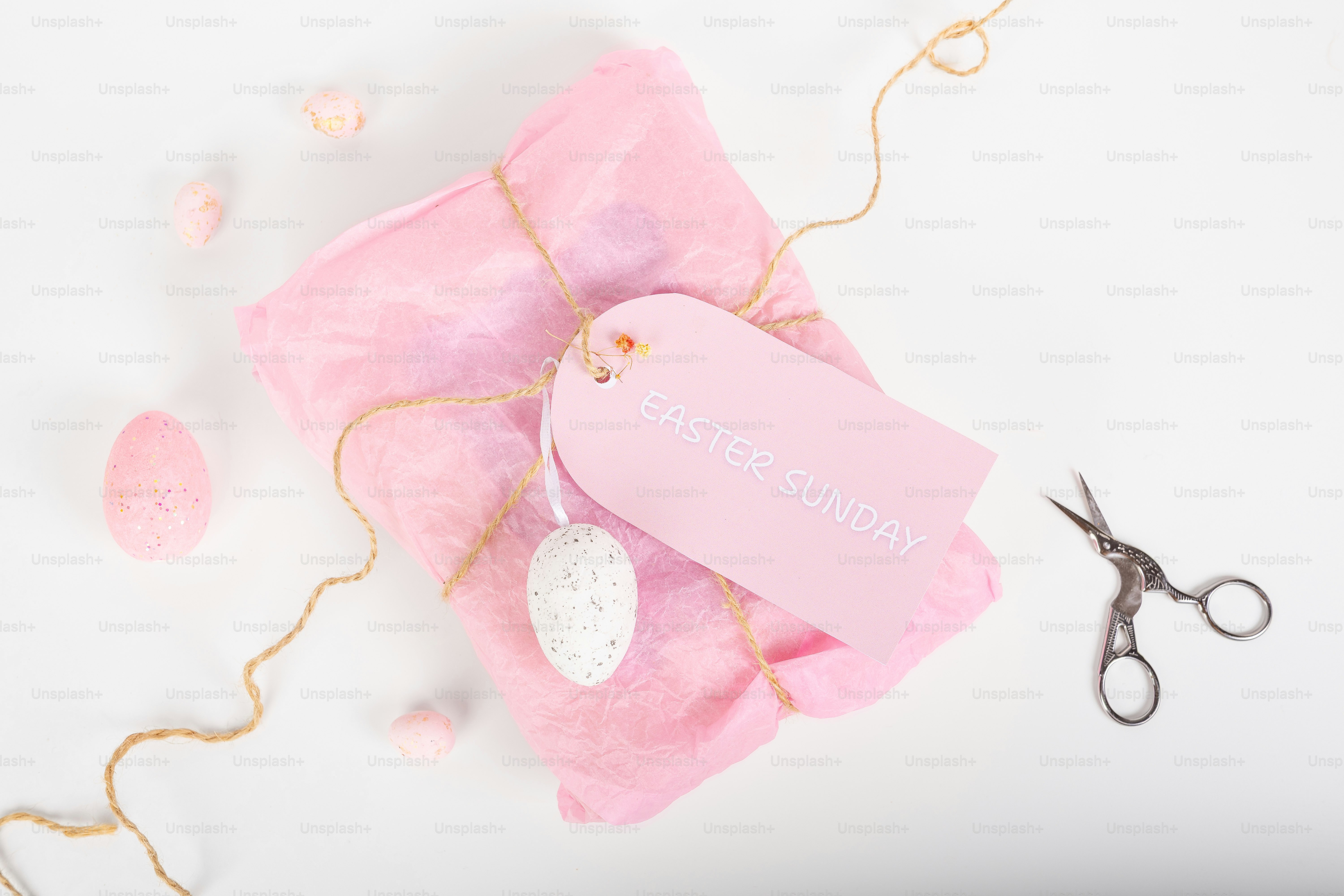 Regalo rosa envuelto con cuerda y decoraciones de Pascua