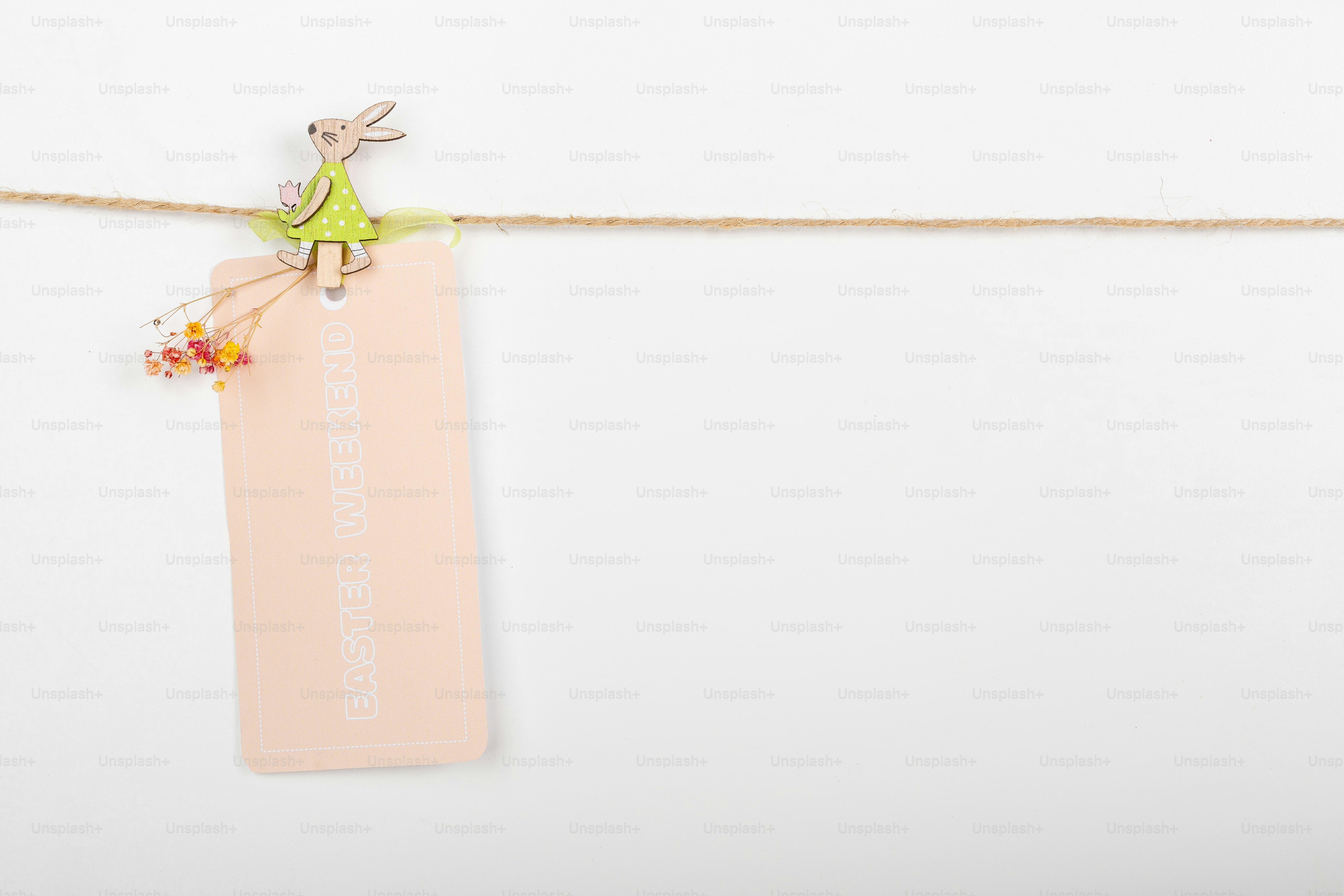 Un clip decorativo sujeta una etiqueta en blanco en un tendedero.