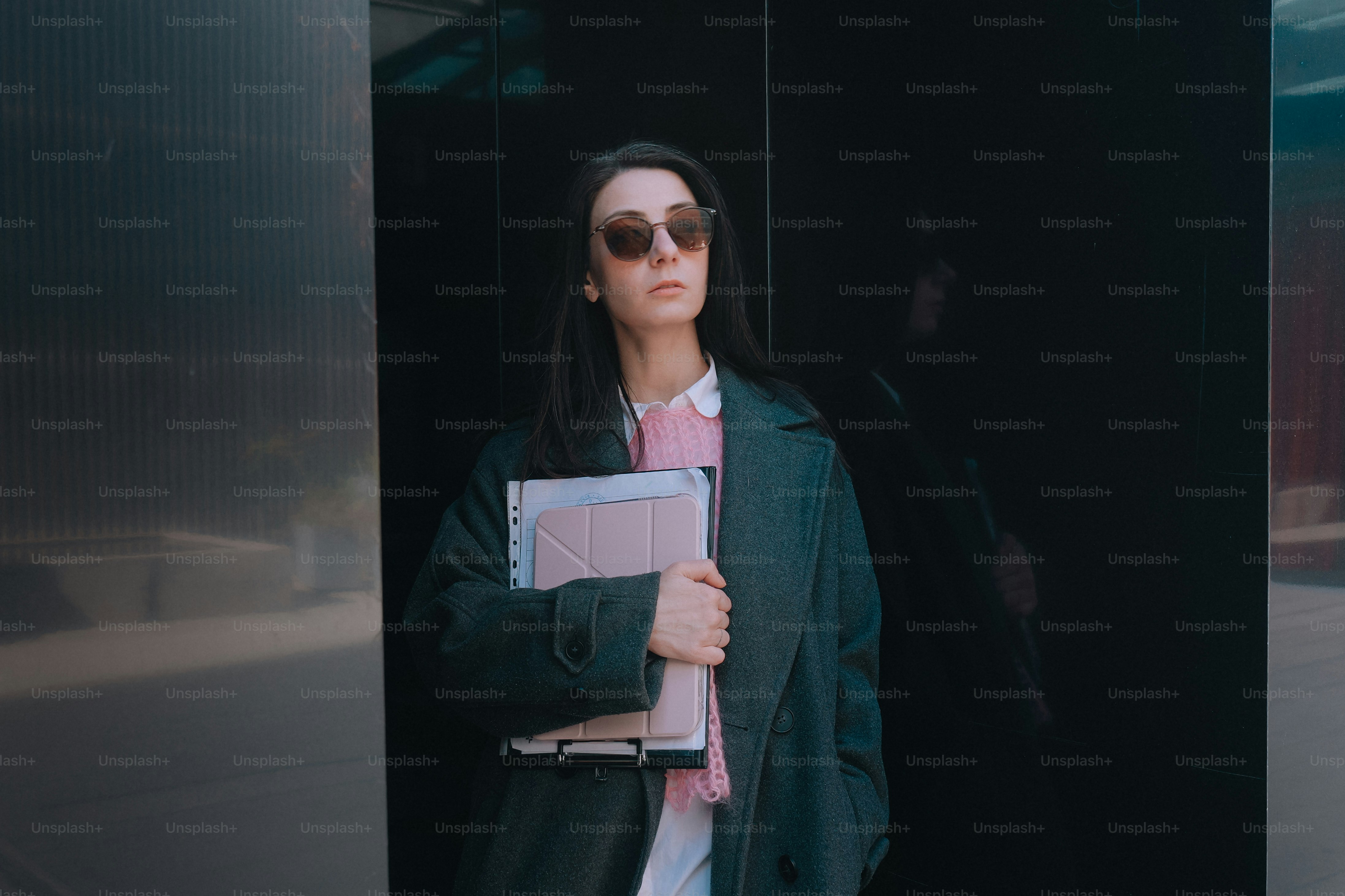 Woman in sunglasses holding a clipboard outdoors