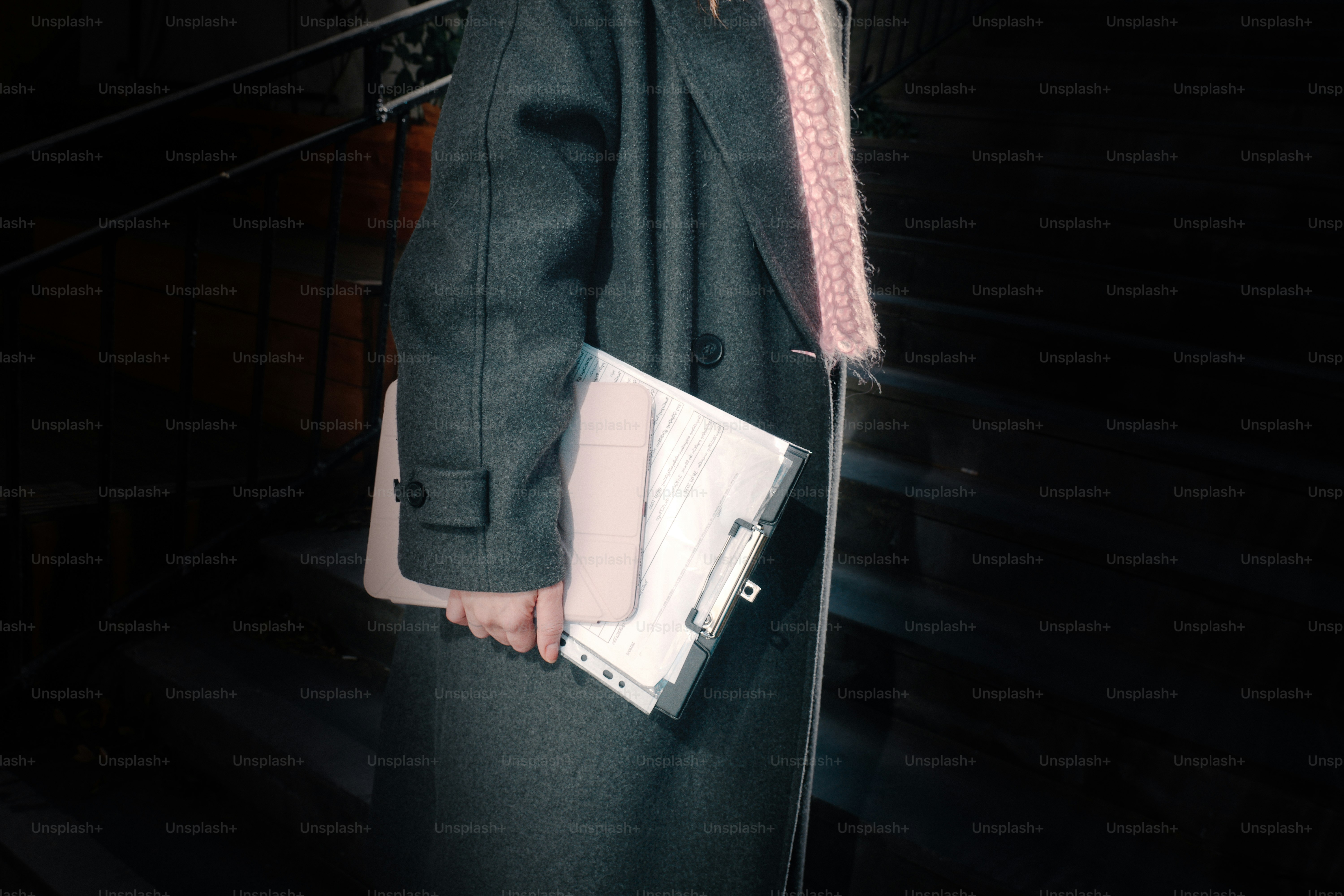 Person holding a clipboard and folder on stairs