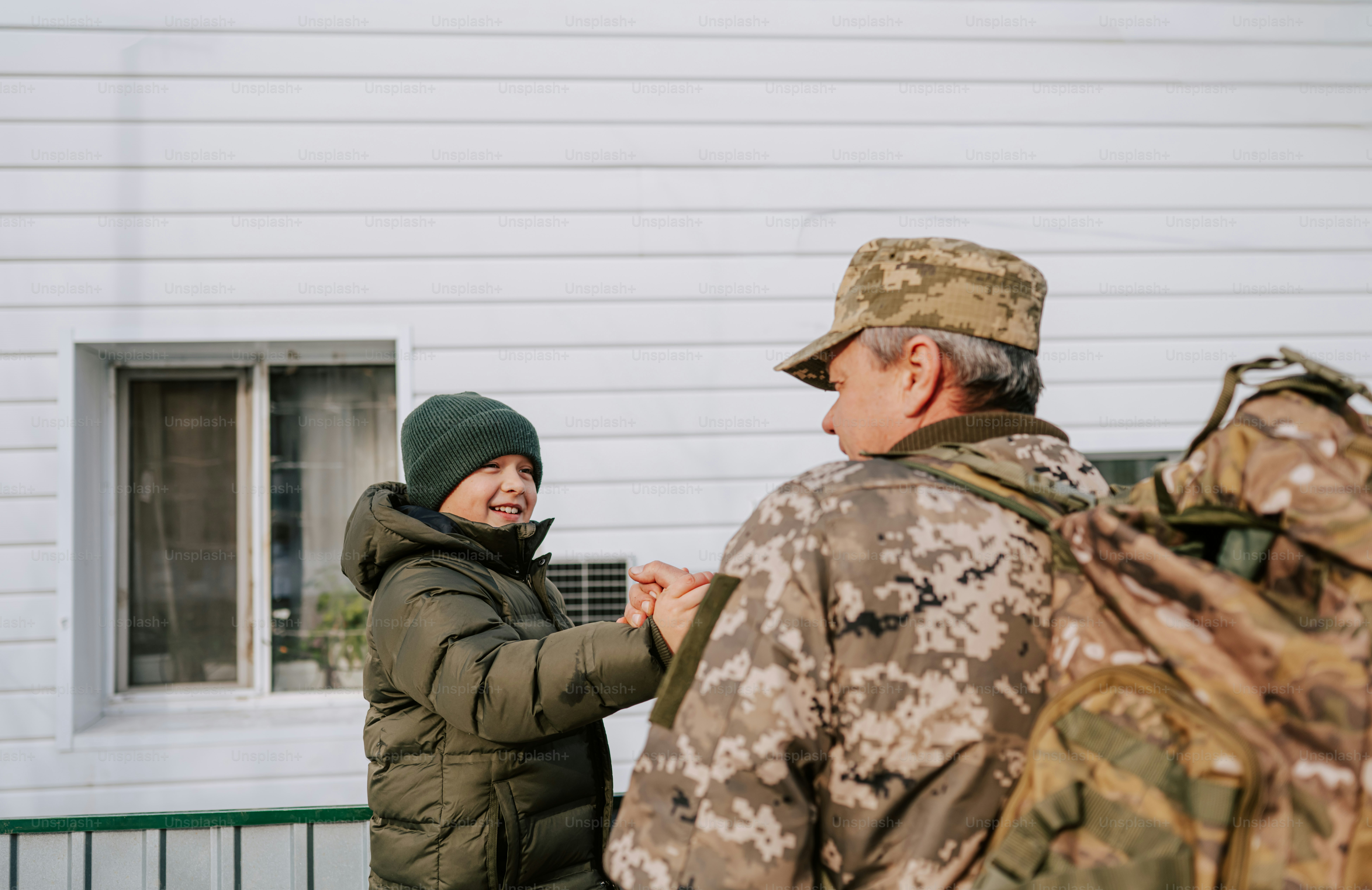 Soldier with backpack greeting a child photo – Family Image on Unsplash