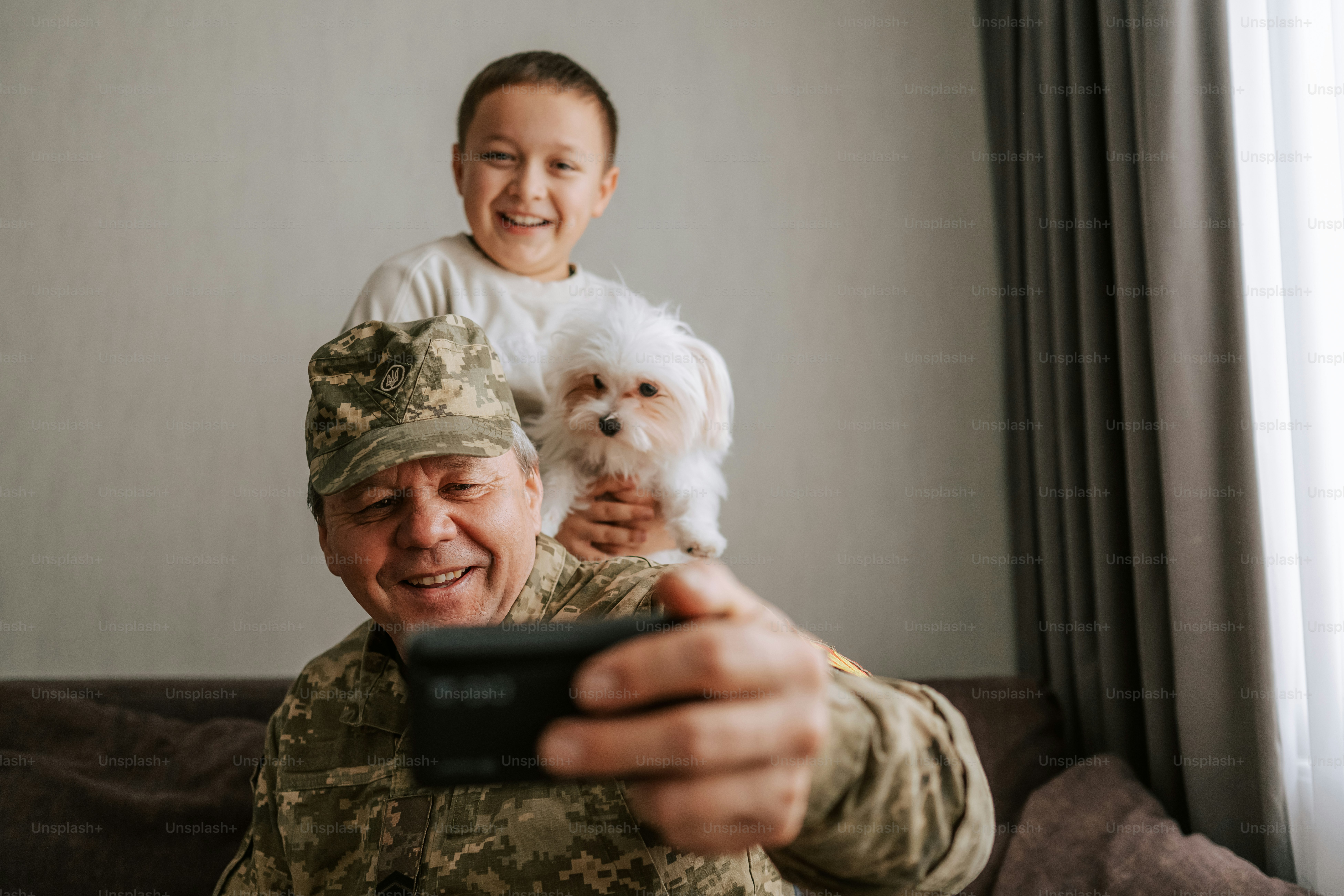Soldado com criança e cachorro tirando uma selfie