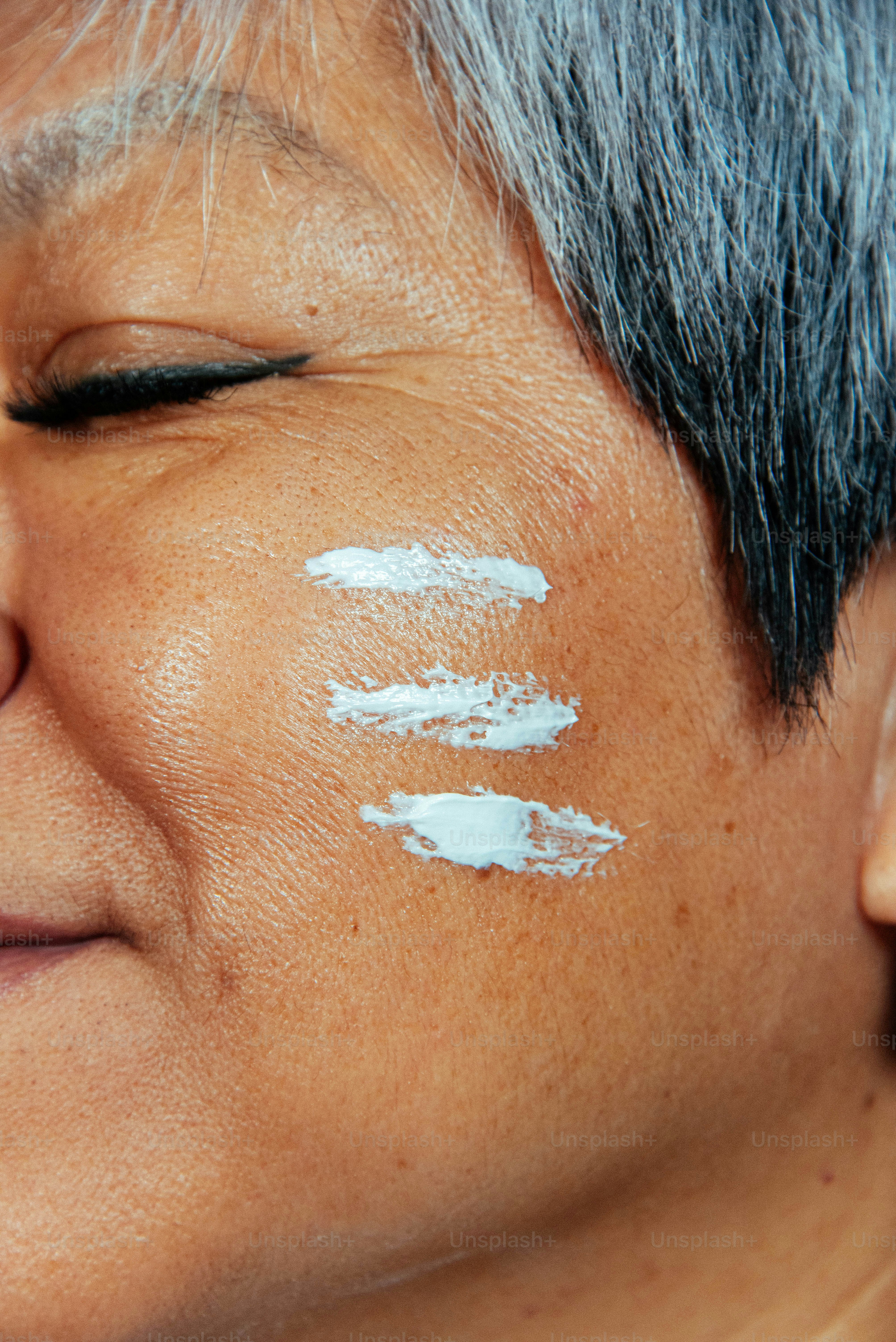 세 개의 크림 샘플을 한 노년 여성의 얼굴.