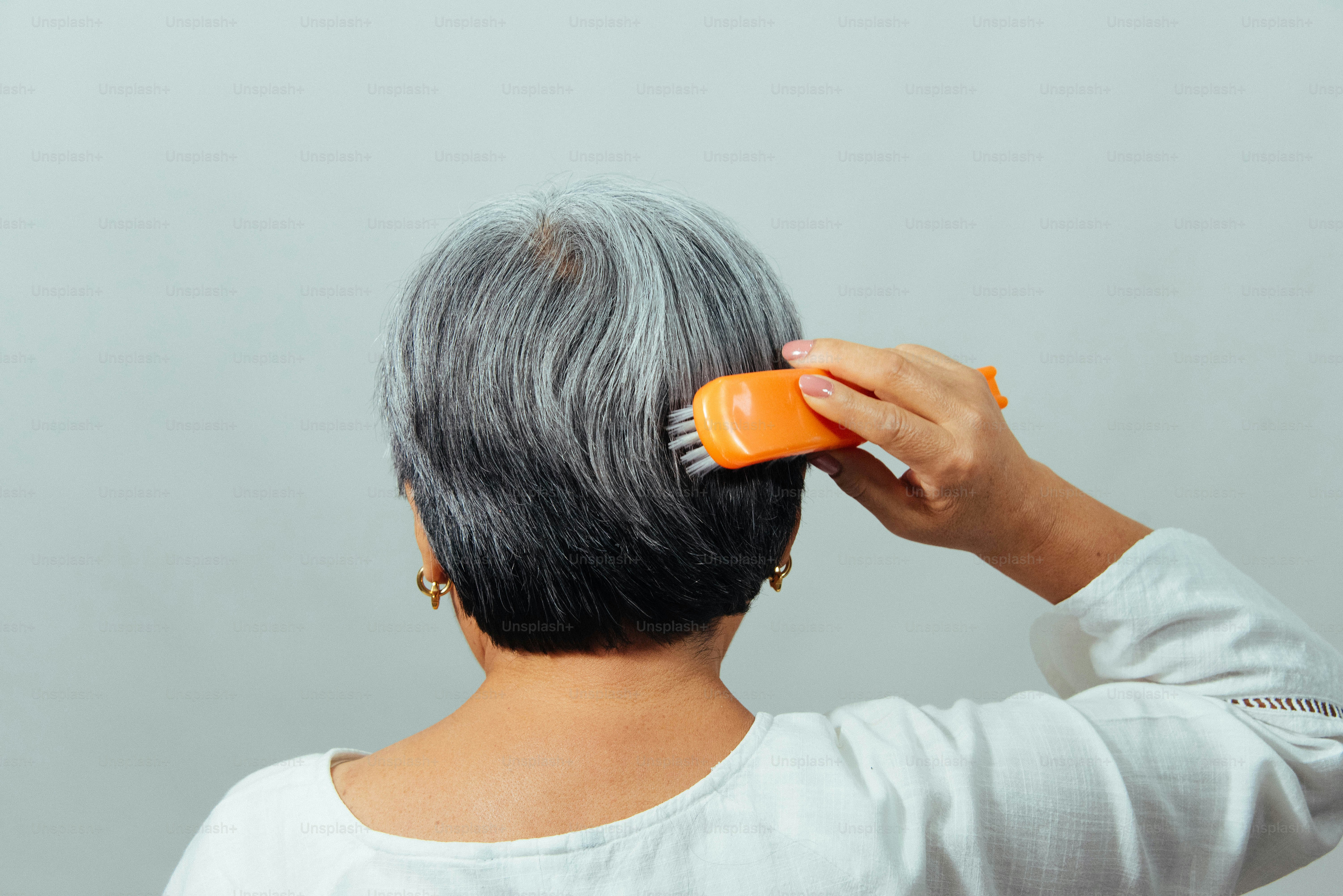 짧은 회색 머리를 빗는 여자