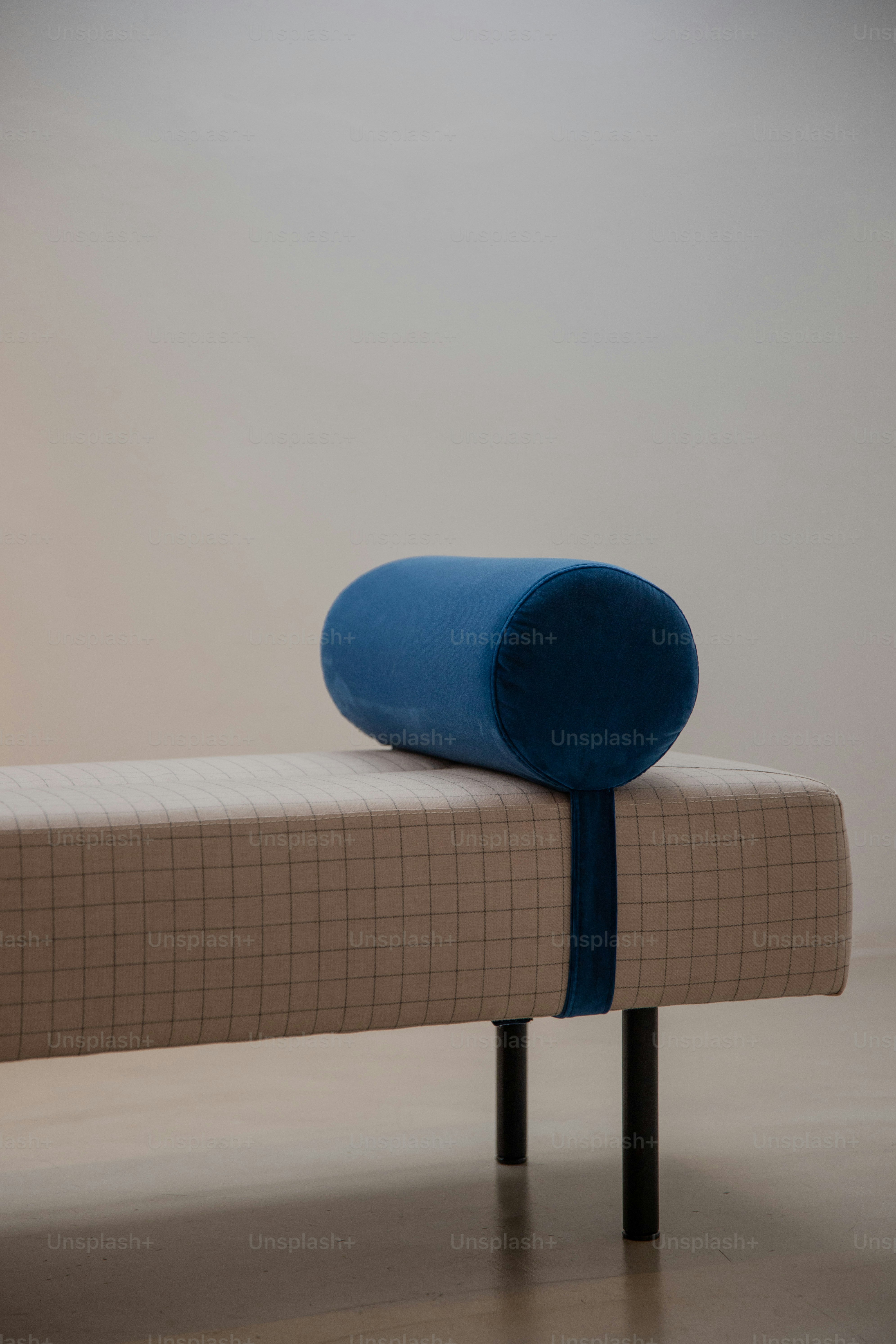 Una cama de día moderna con una almohada azul de almohada.