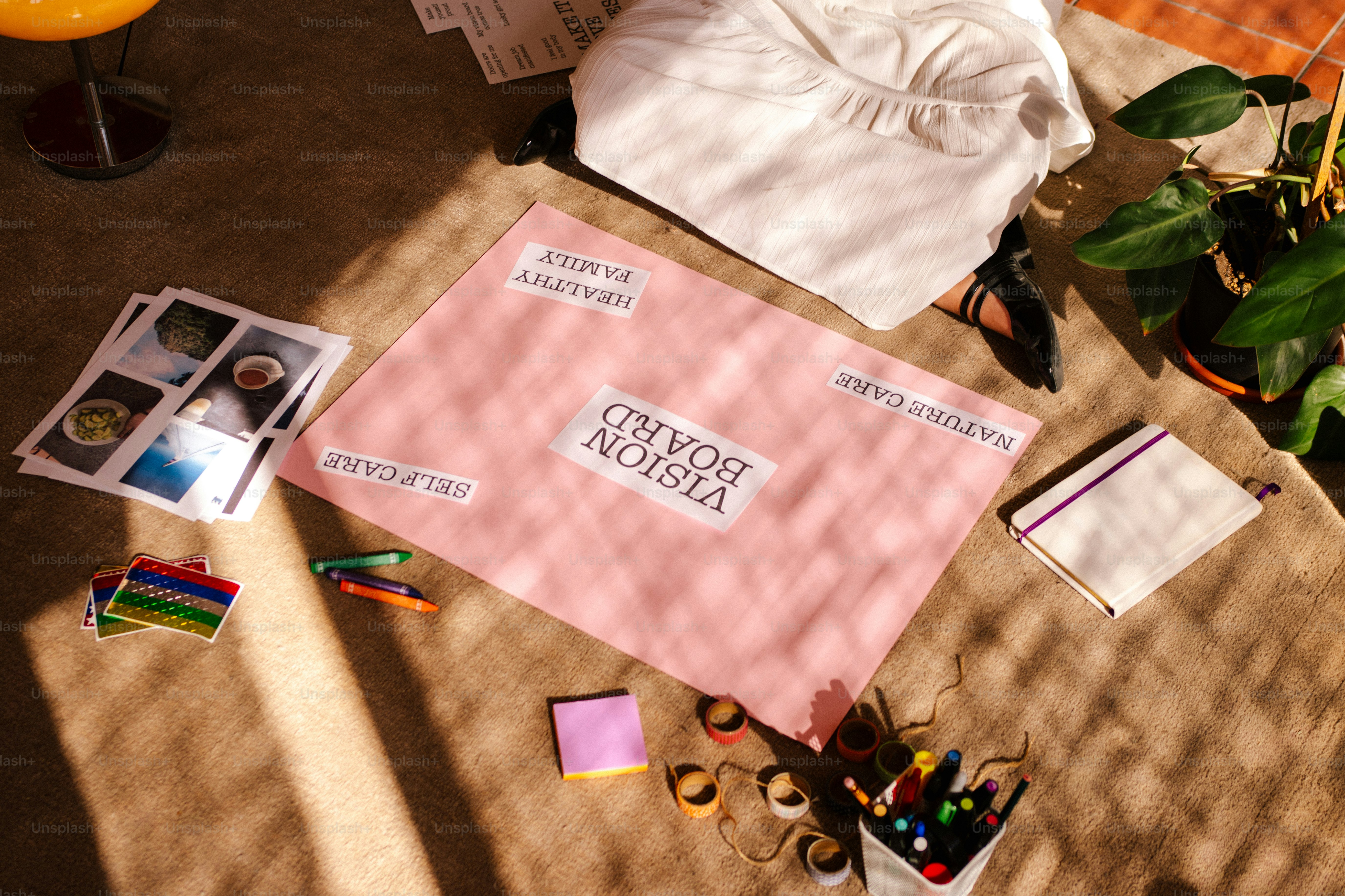Pink vision board with craft supplies and inspirational images.