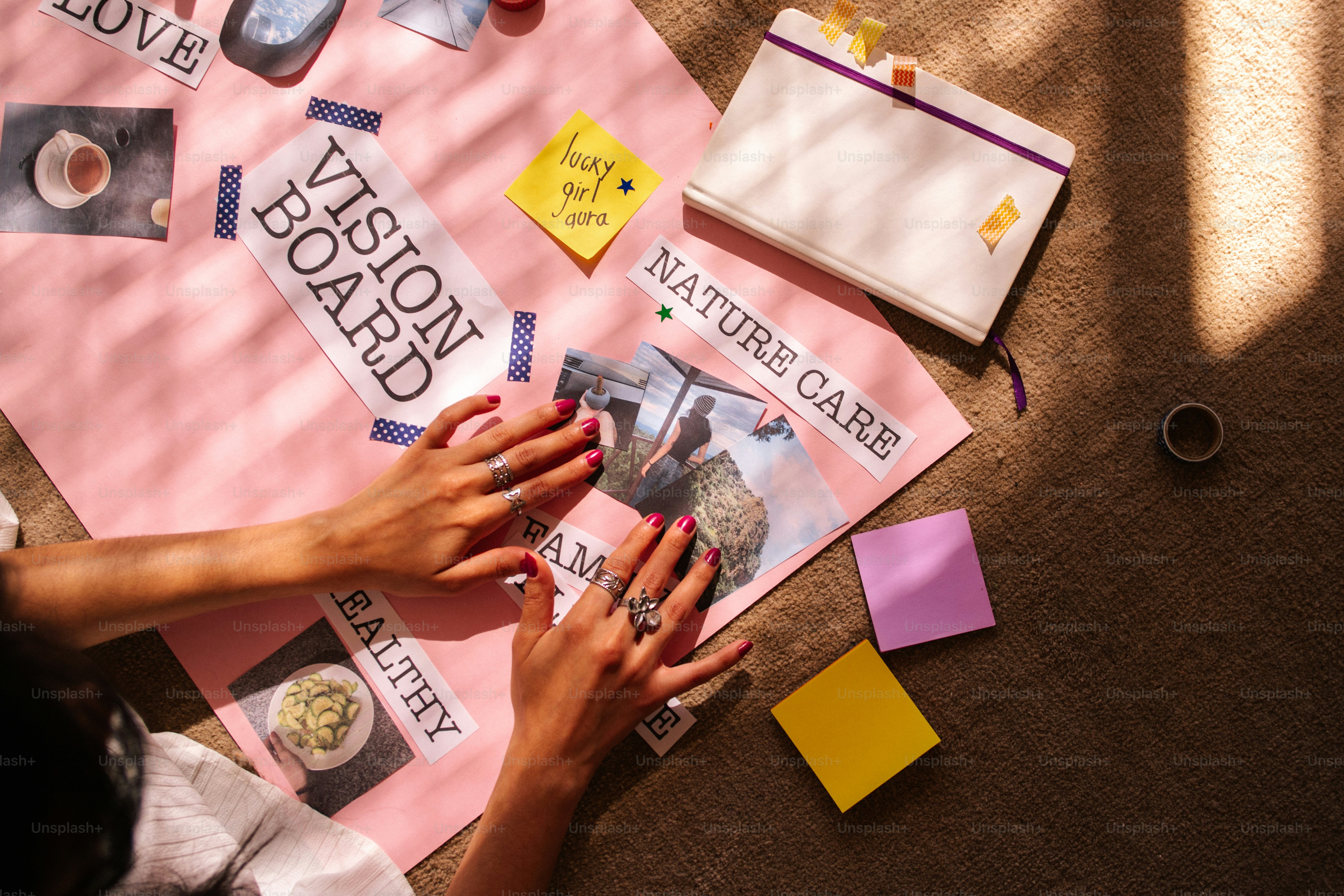 Hands creating a vision board with inspirational words and images.