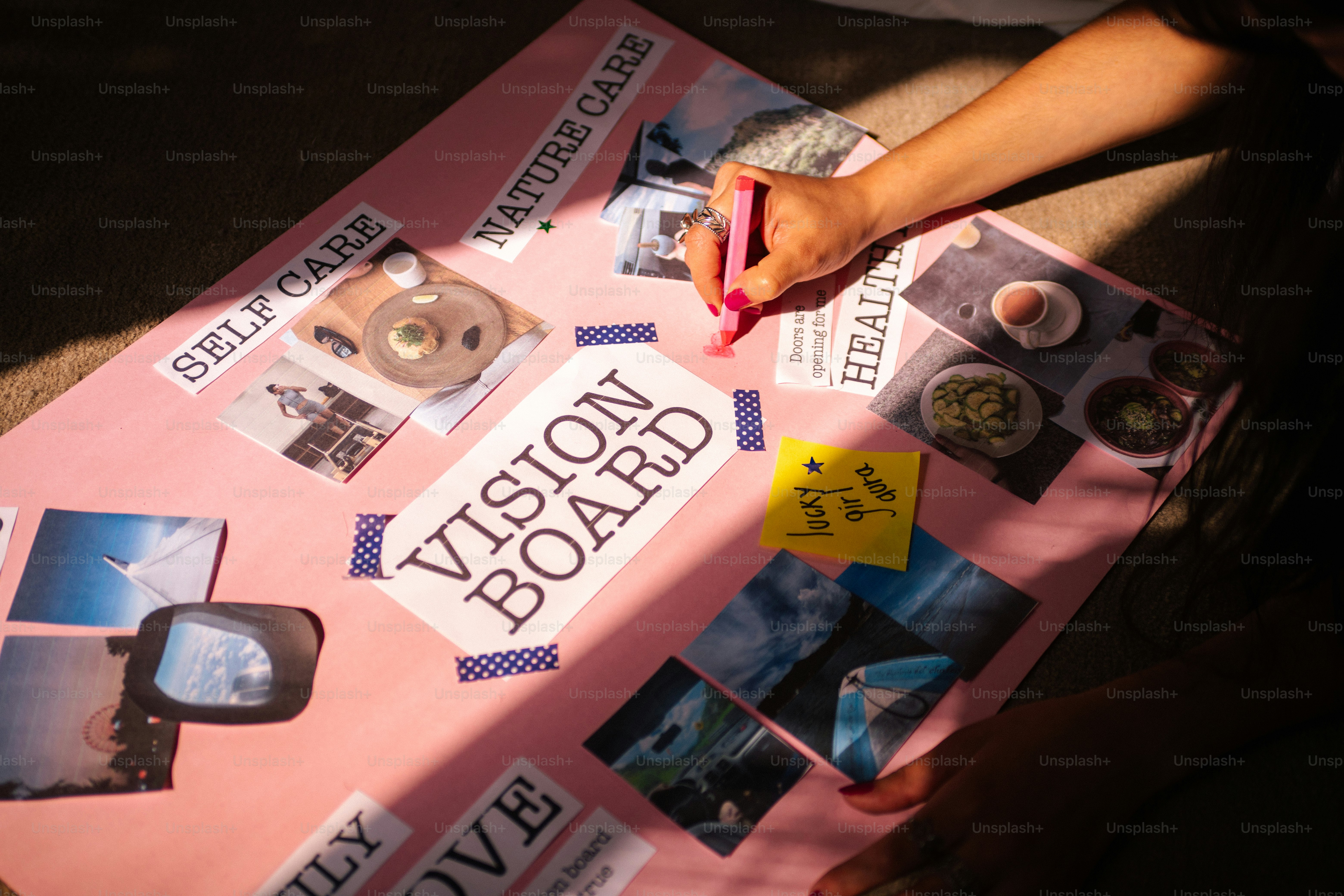 Person creating a vision board with various images and words.