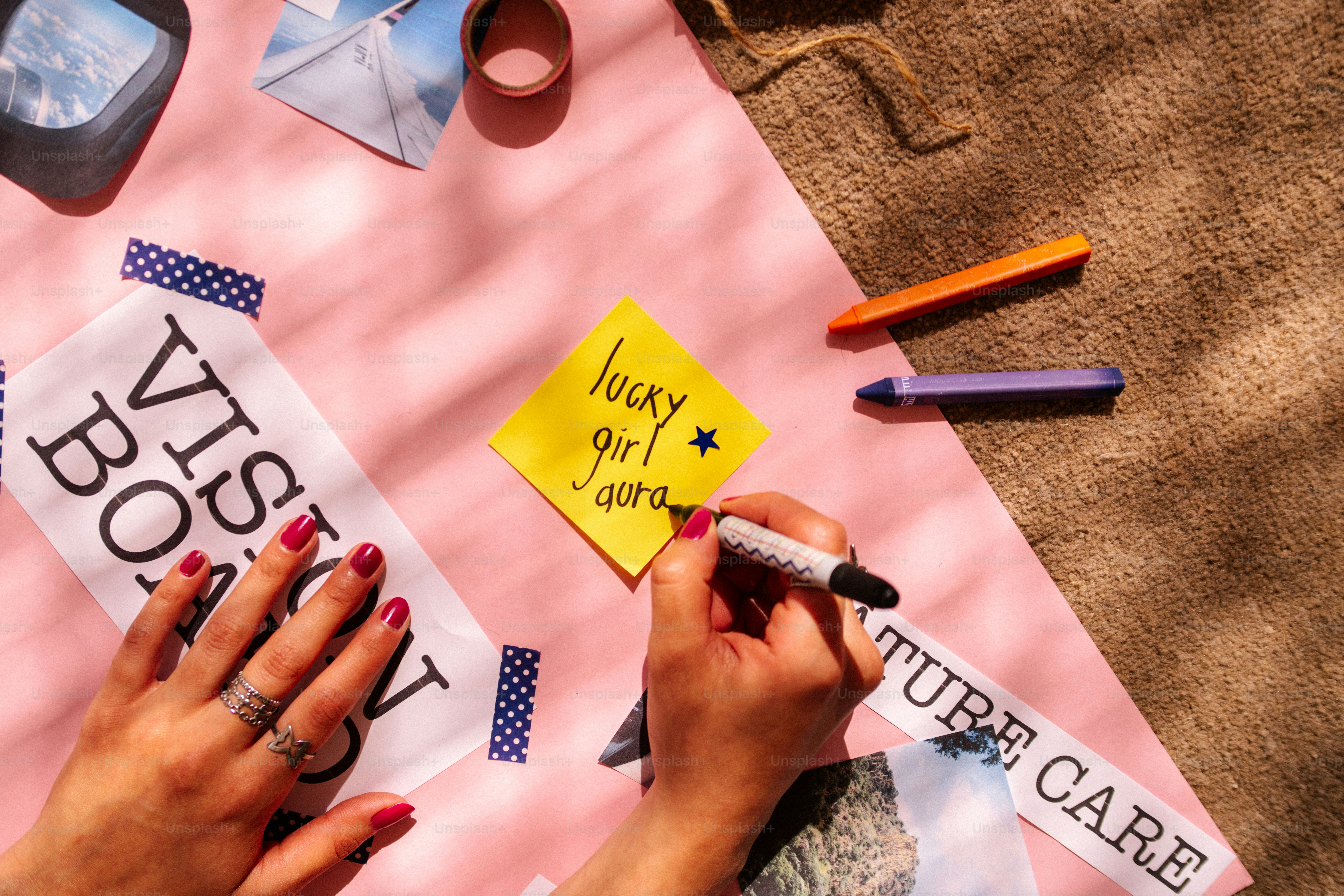 Hands creating a vision board with sticky notes and images.