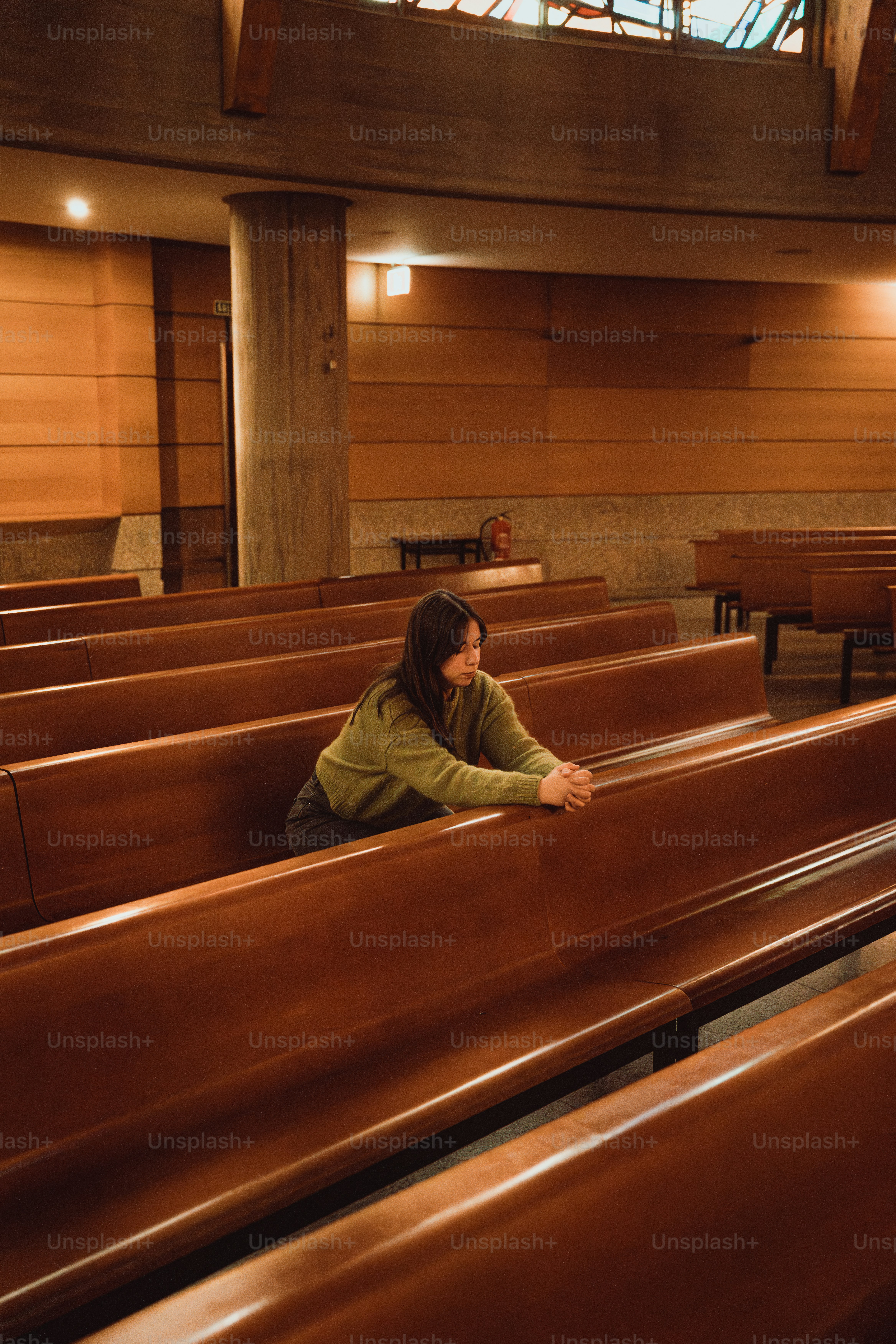 A woman praying in a church pew