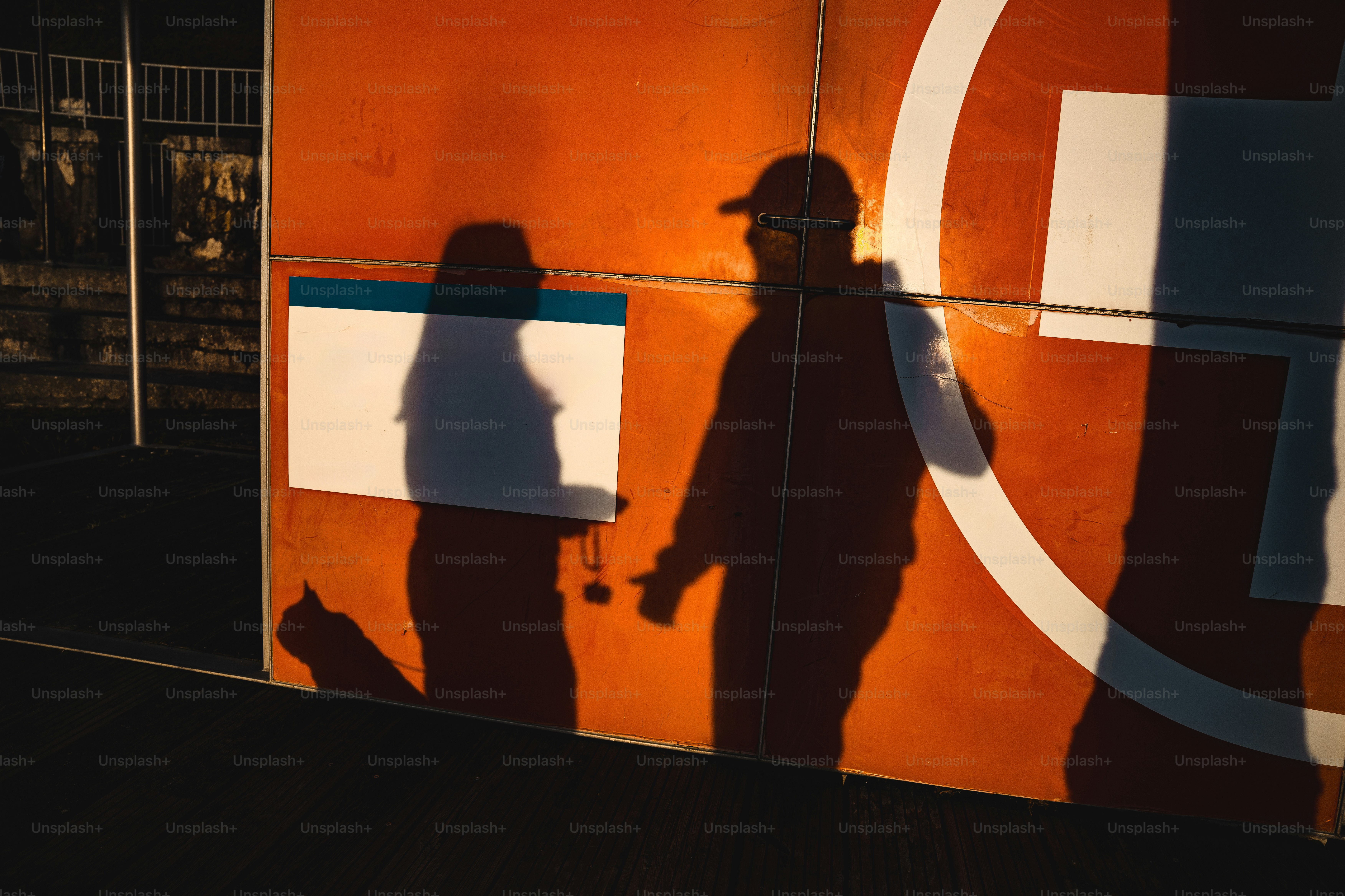Two shadows cast on an orange wall photo – People Image on Unsplash