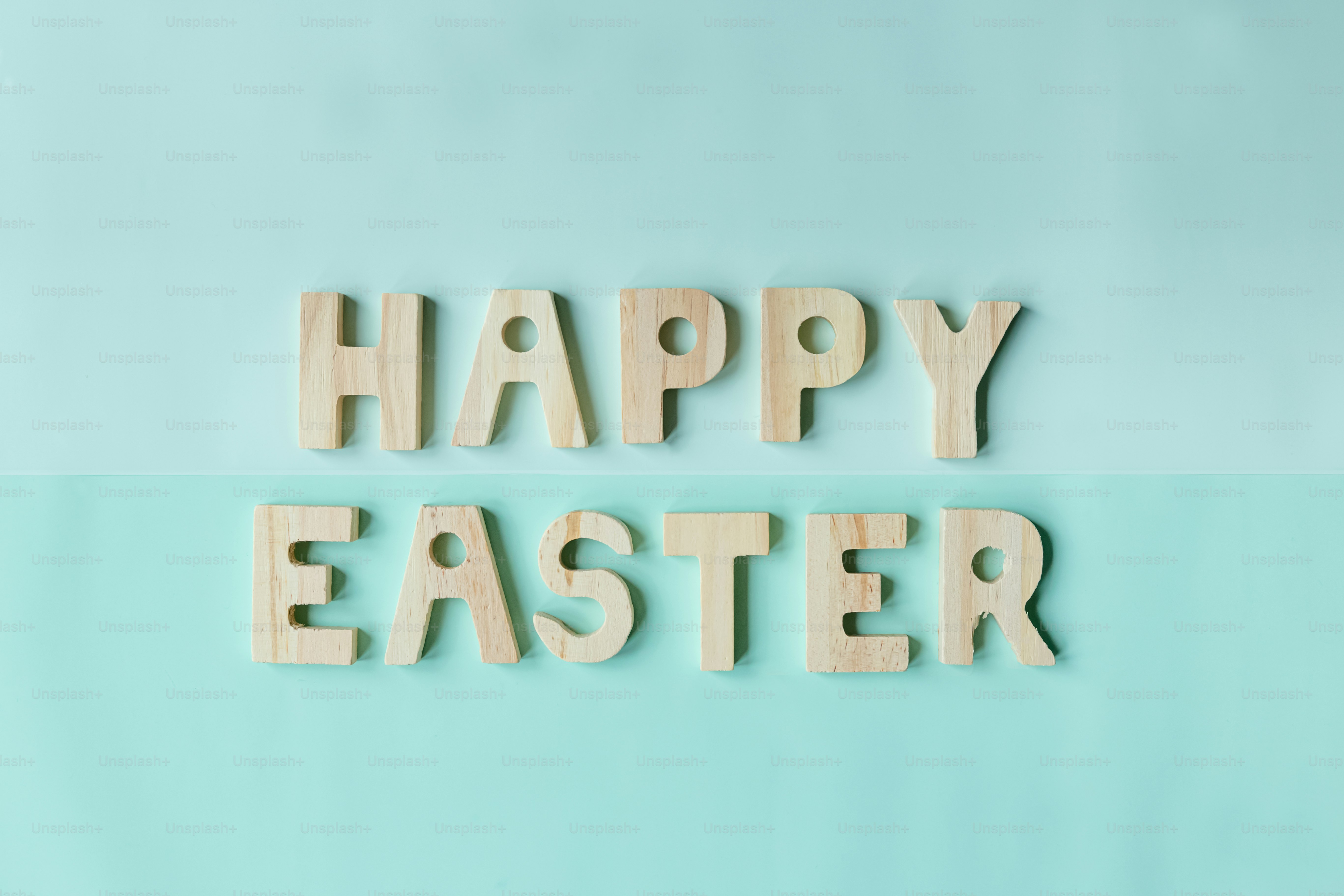 木製の文字で青い背景に「ハッピーイースター」と書かれています。