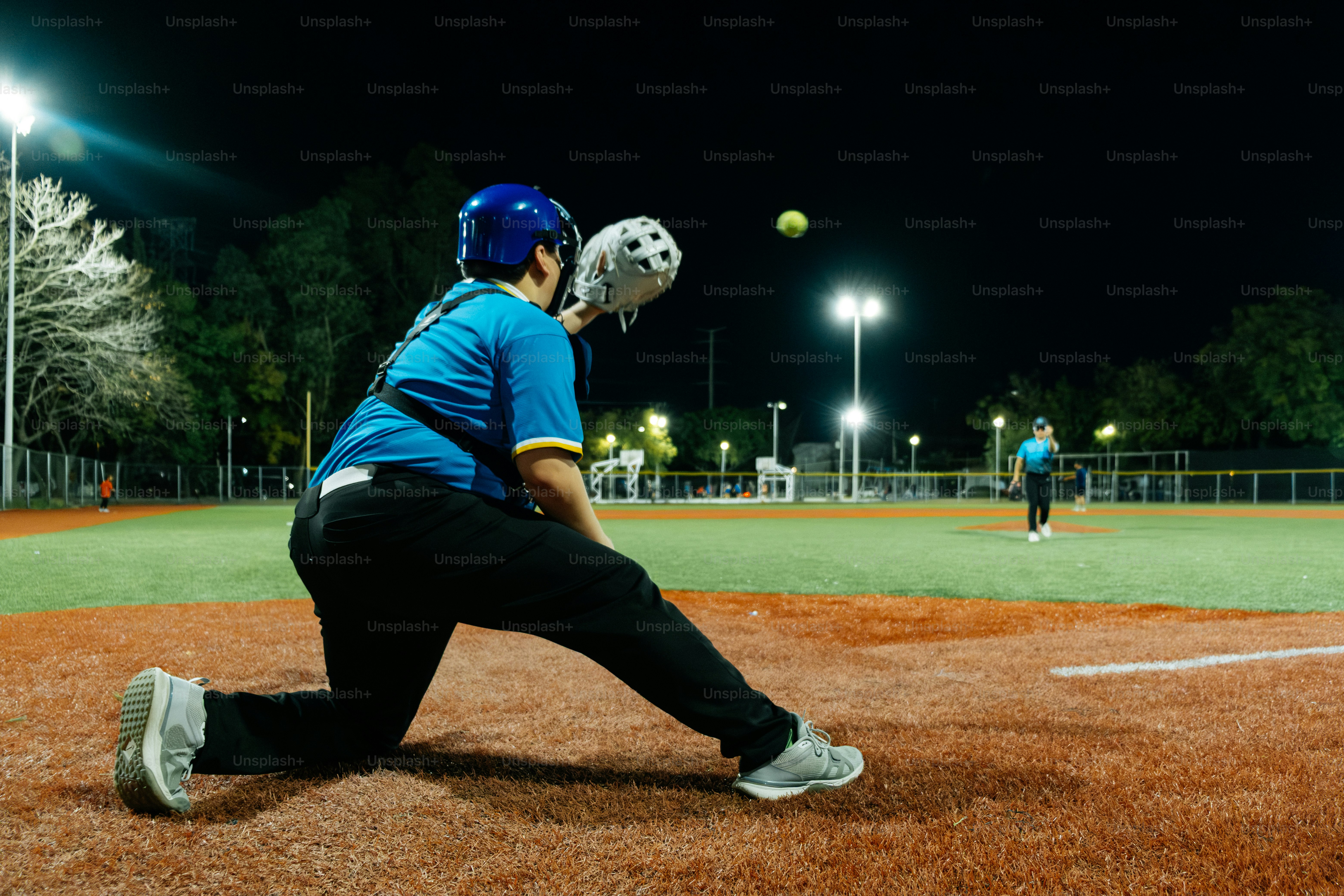 Joueuse de softball attrapant la balle sur le terrain la nuit