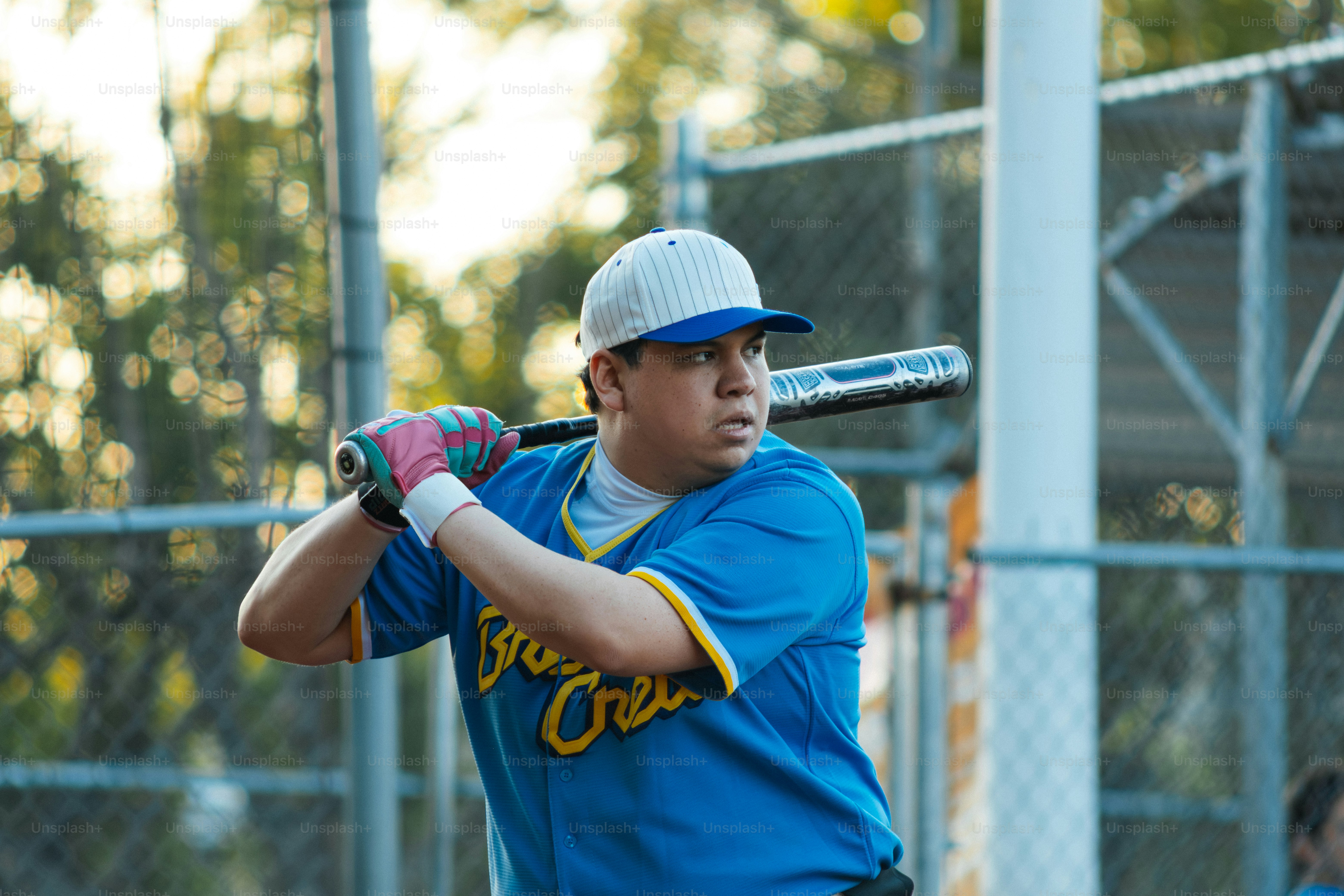 Un homme en maillot bleu balance une batte de baseball au match.