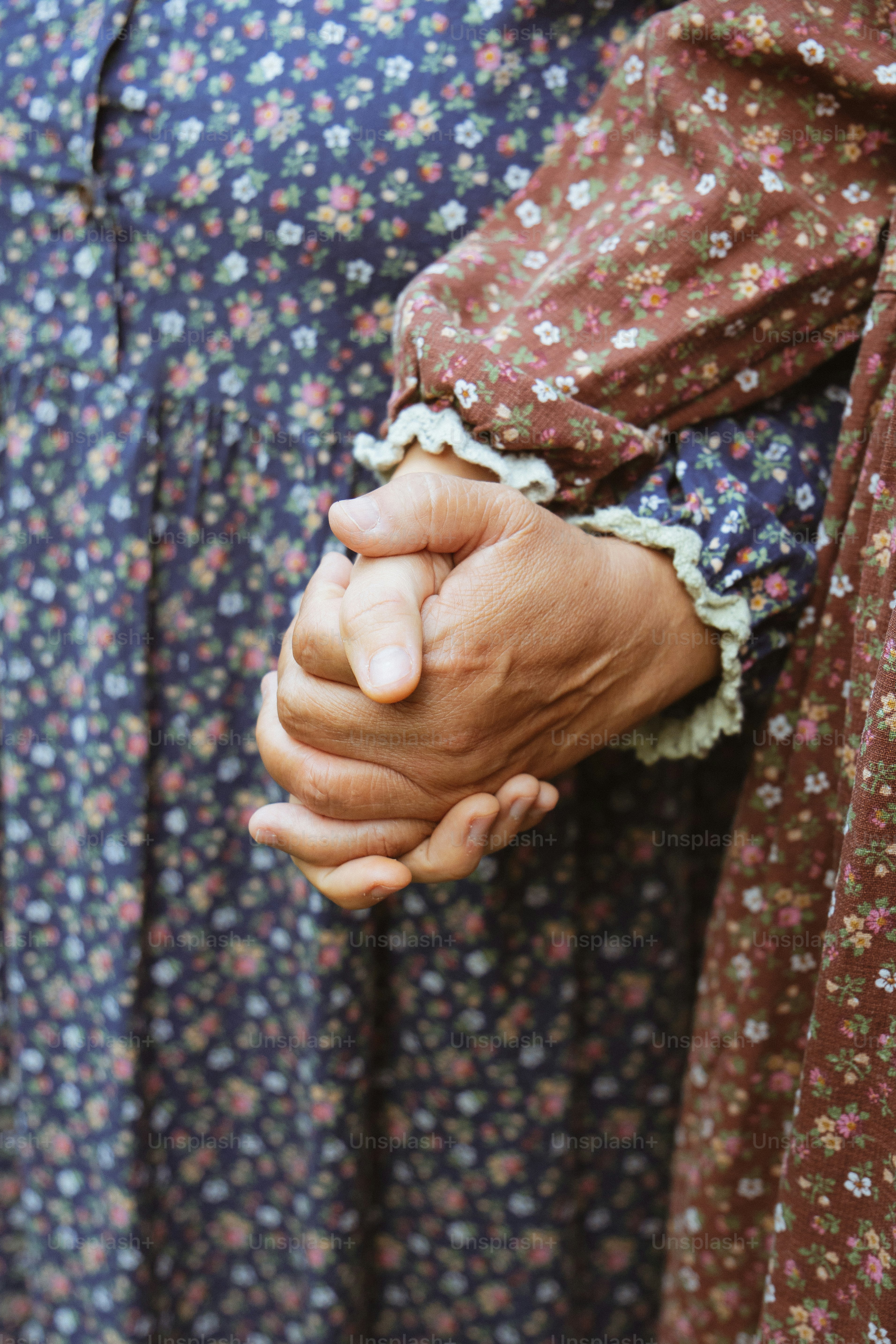 Zwei Frauen in Blumenkleidern, die Händchen halten