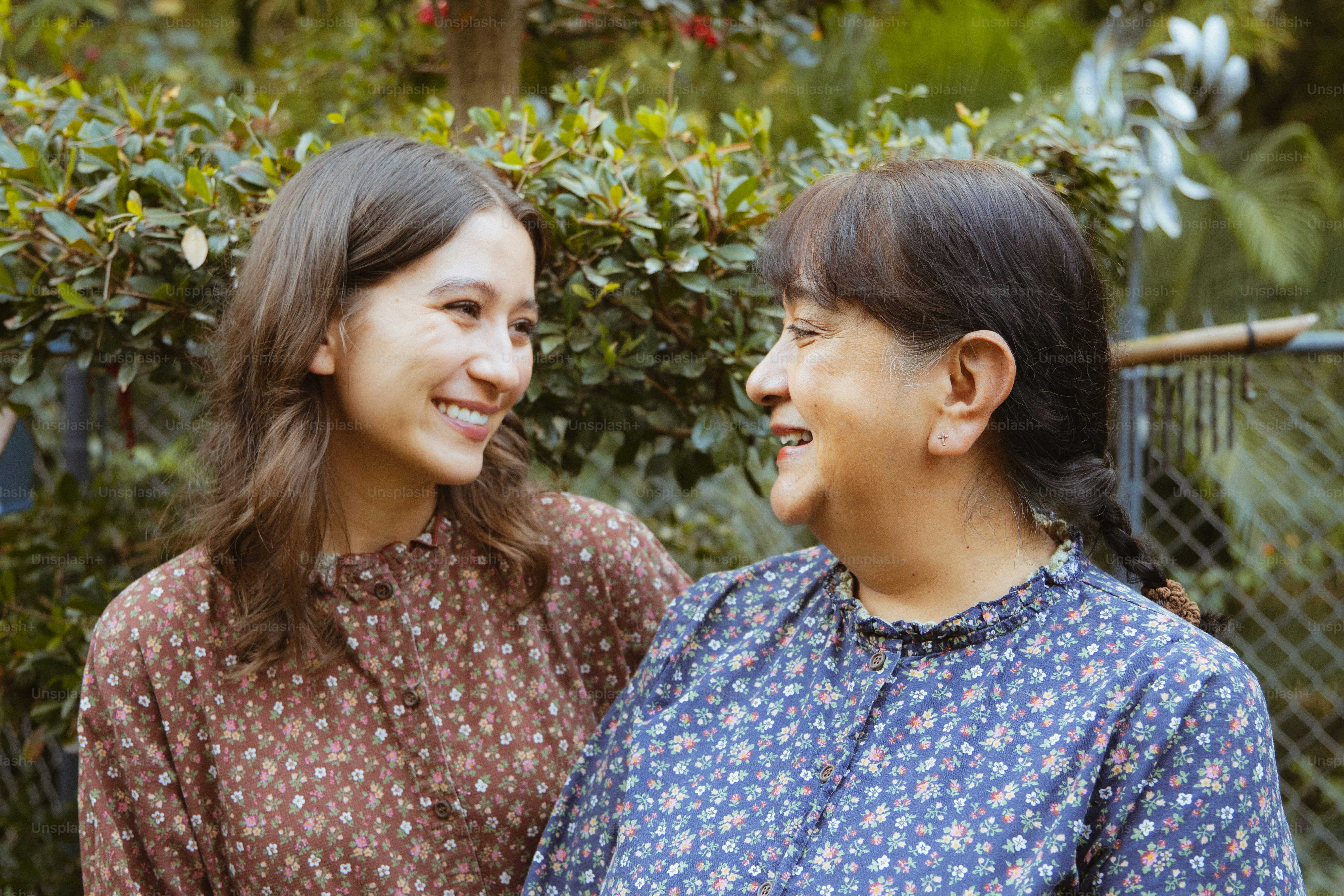 Zwei Frauen, die sich draußen anlächeln.