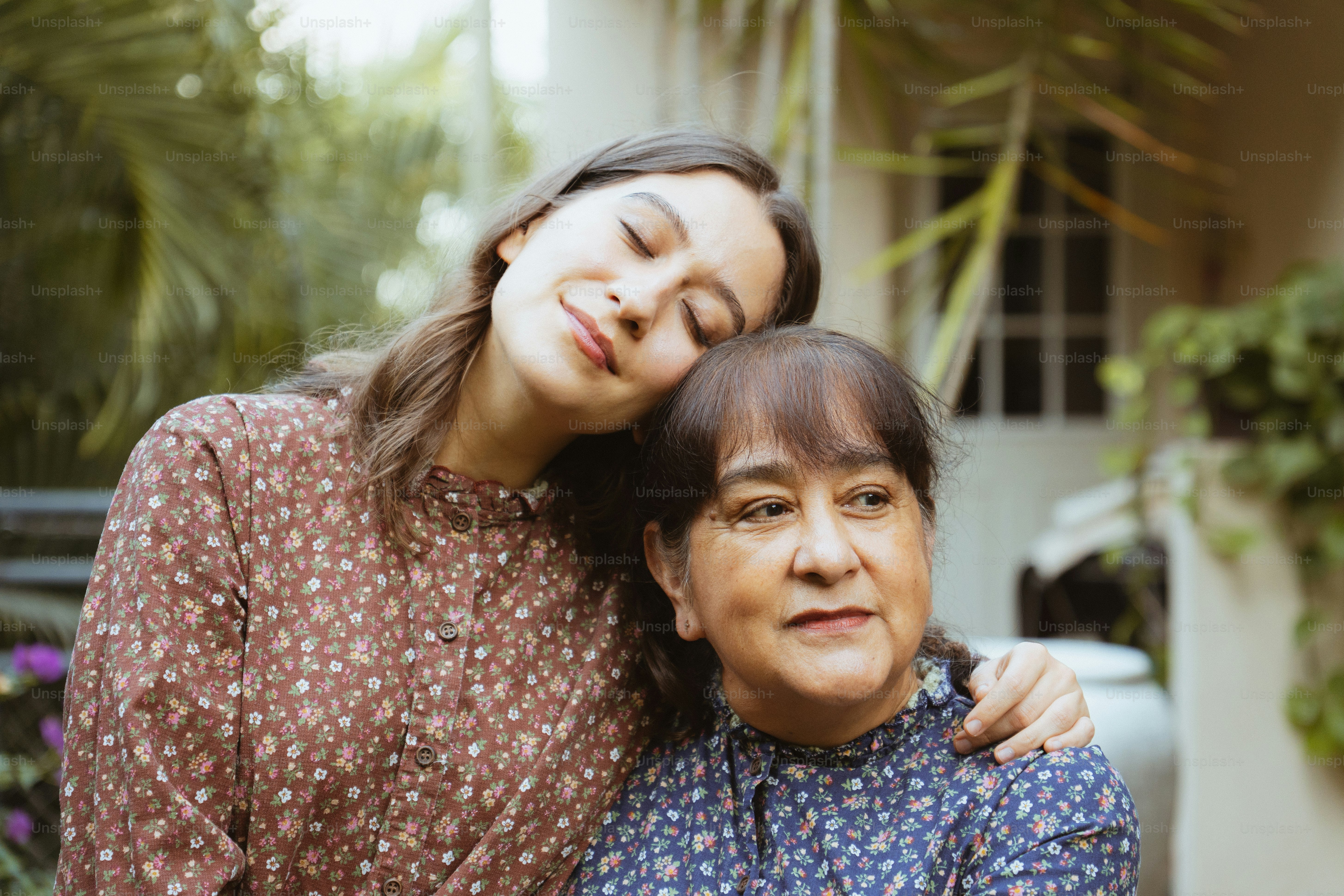 Zwei Frauen, die draußen mit einer warmen, liebevollen Verbindung umarmen.