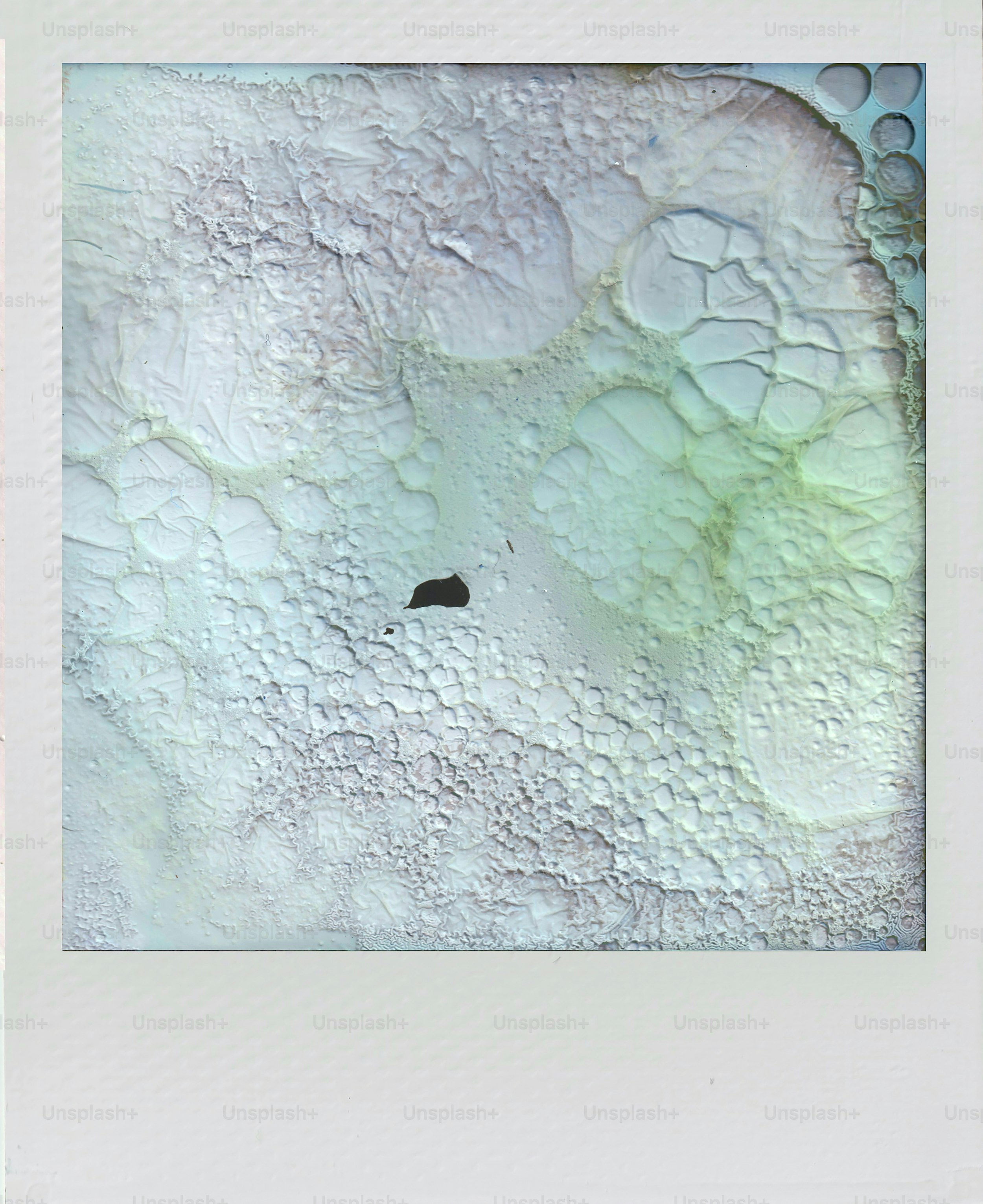 Abstract textured surface with bubbles and pastel colors.