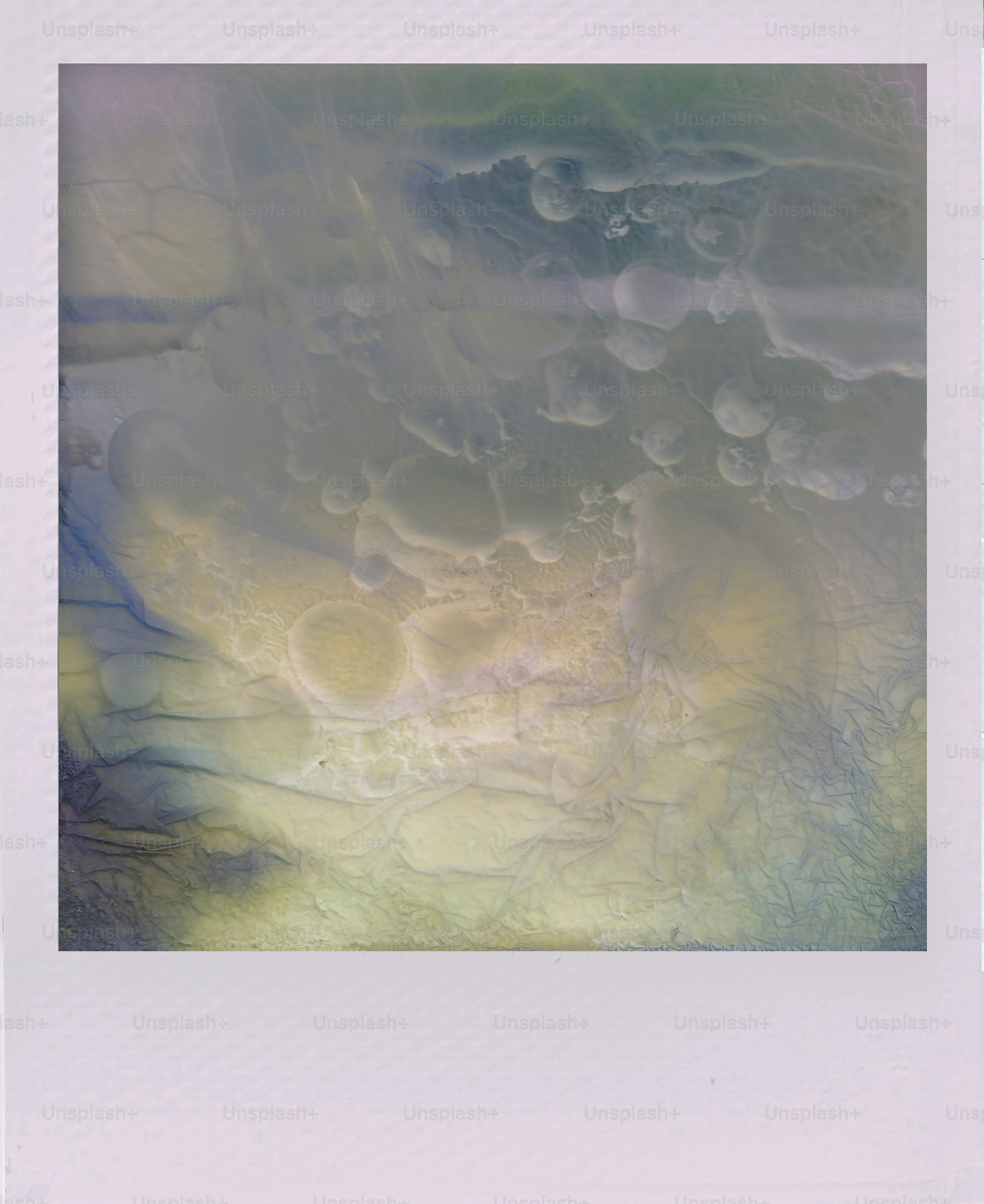 Abstract swirls of blue, yellow, and green colors.