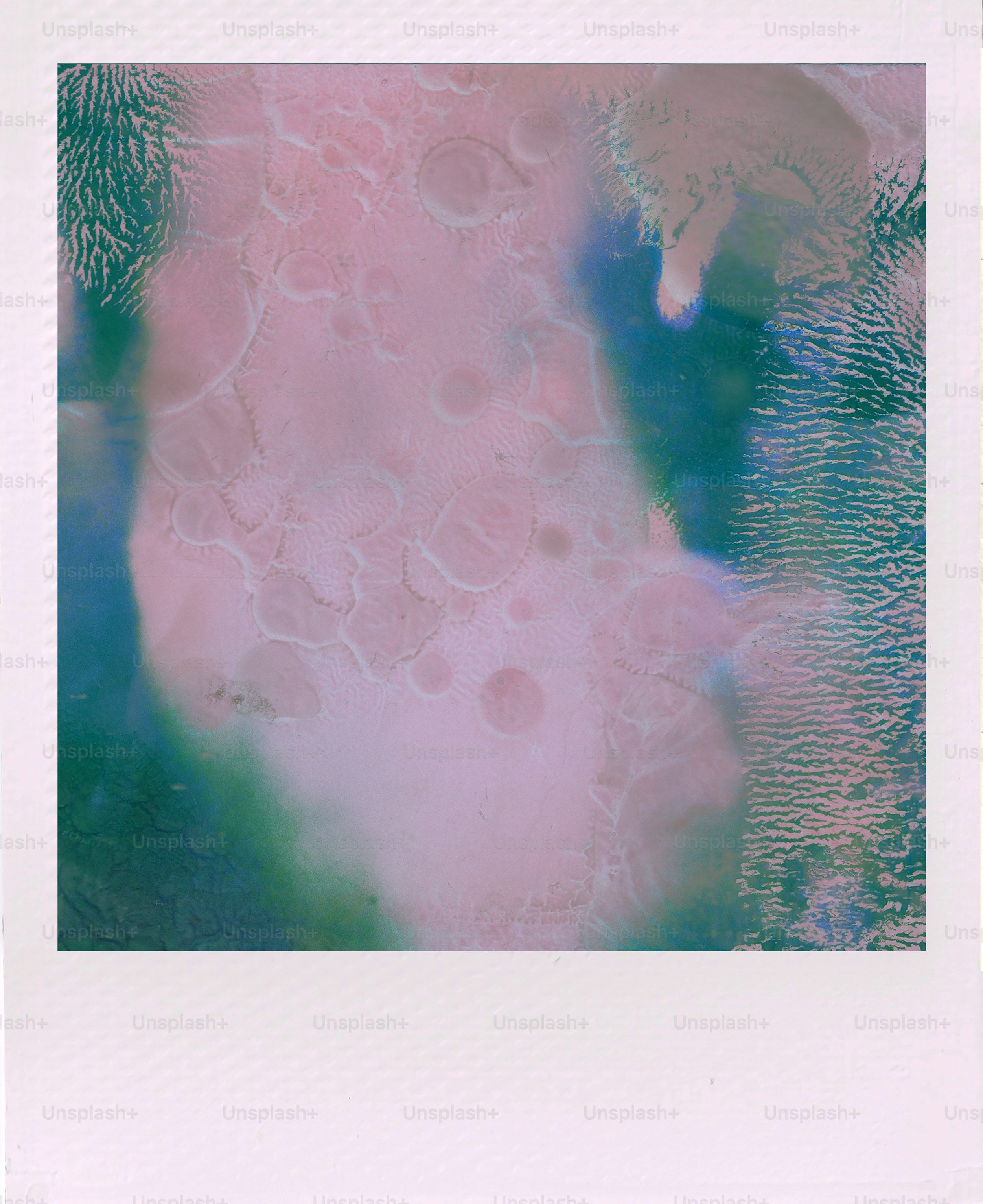 Abstract watercolor with pink, blue, and green hues.