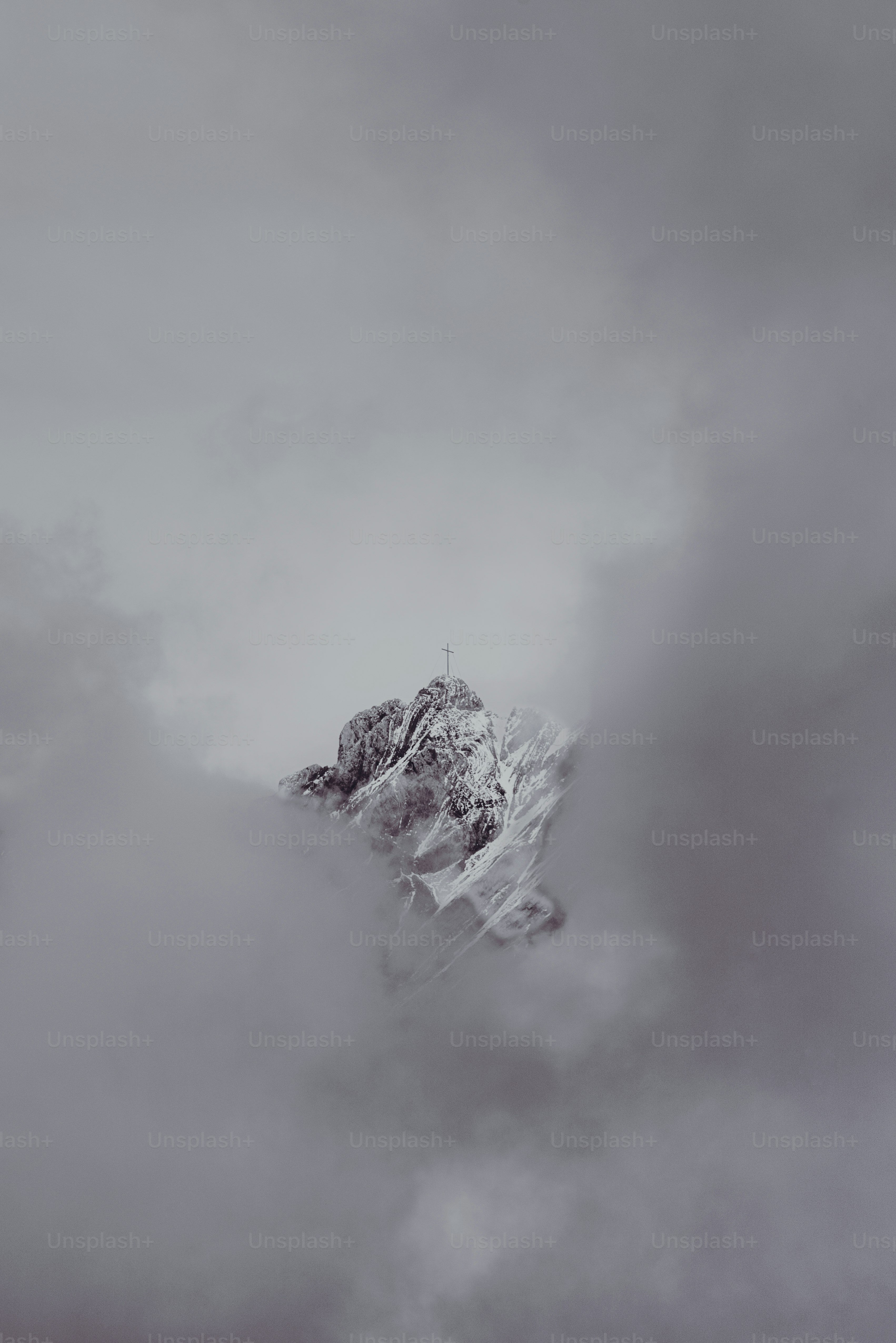 Snowy mountain peak emerges from swirling clouds