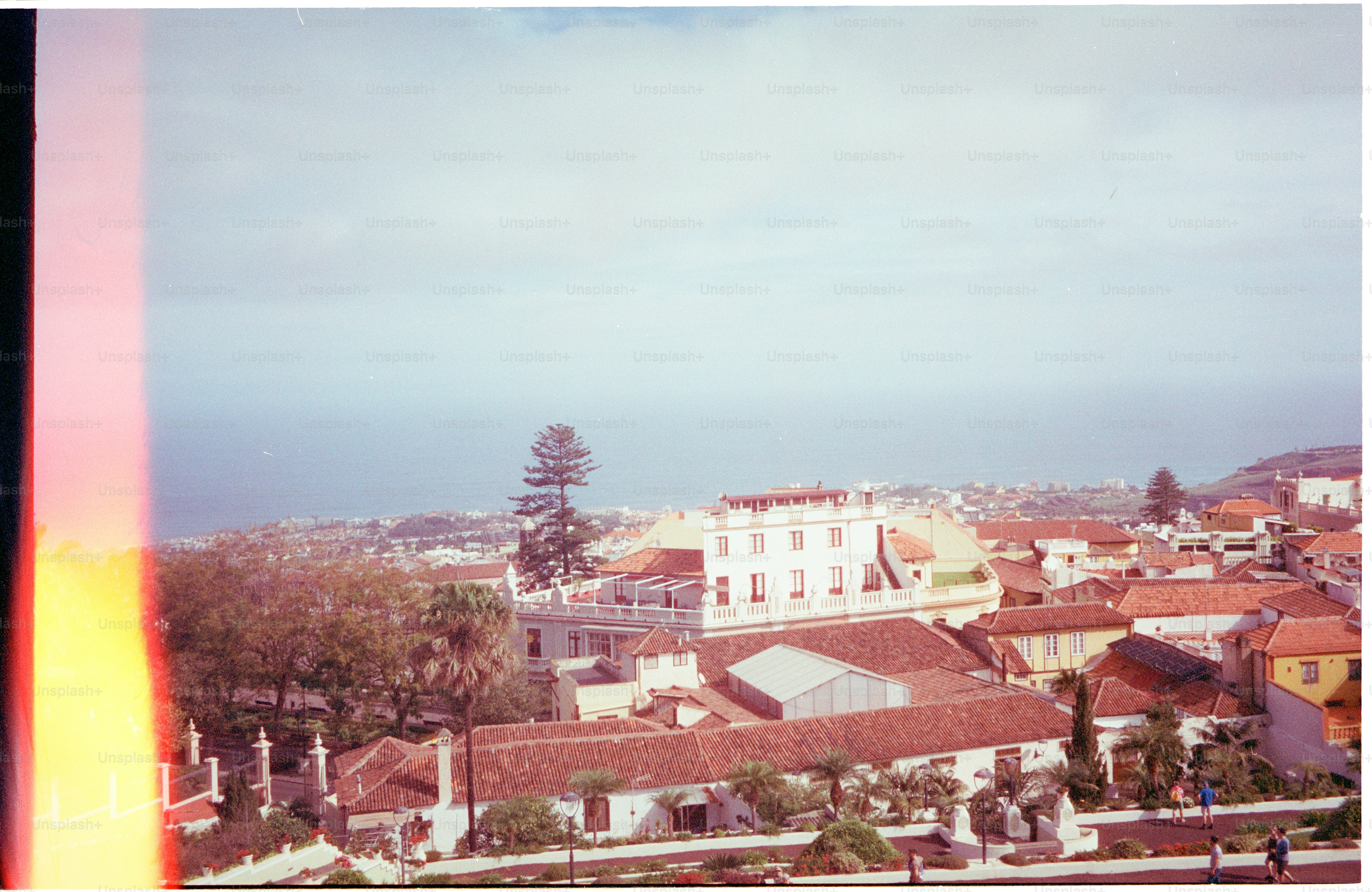 Dächer einer Stadt mit dem Meer im Hintergrund.