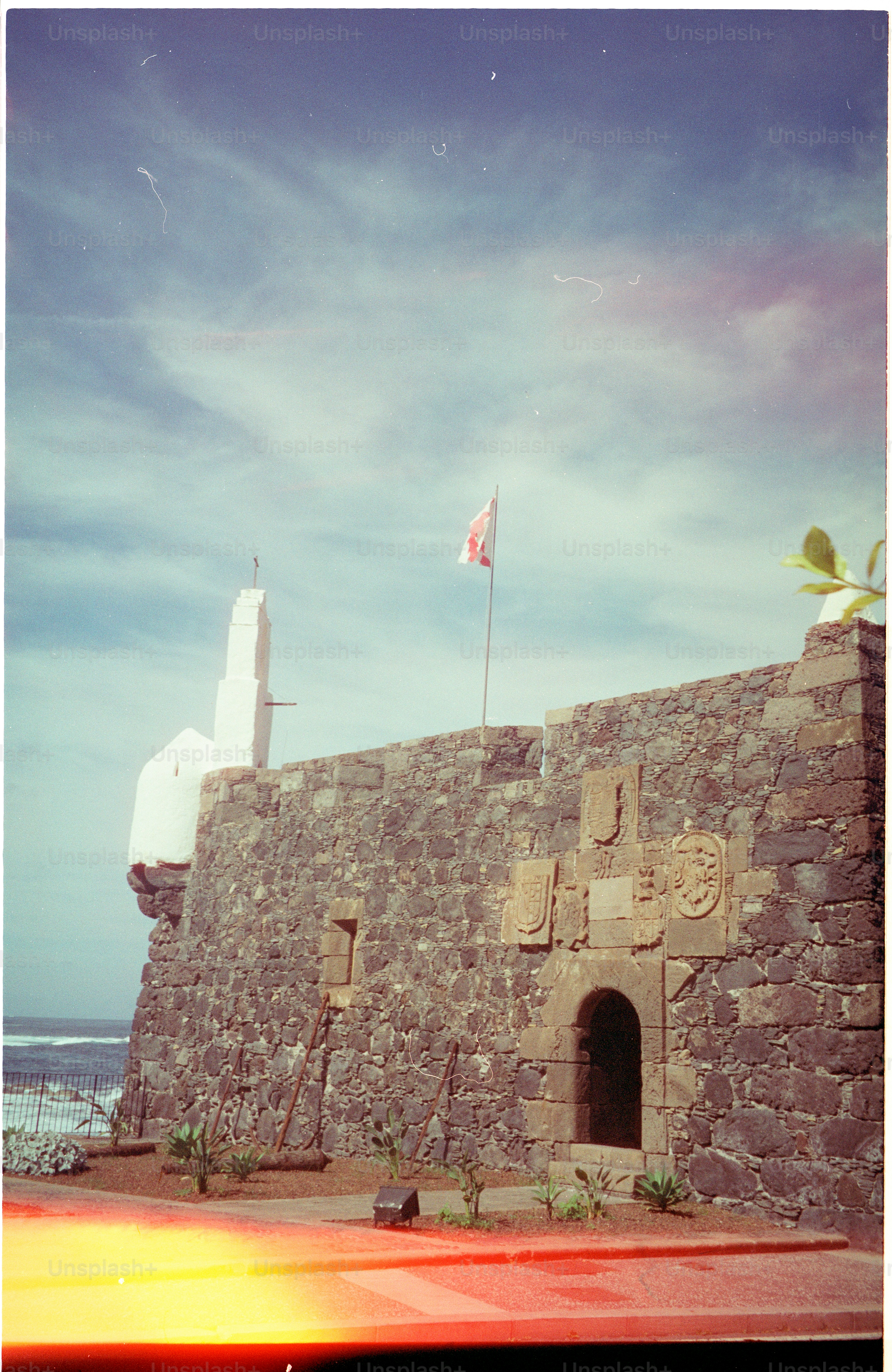 Stone fortress with a flag under a cloudy sky