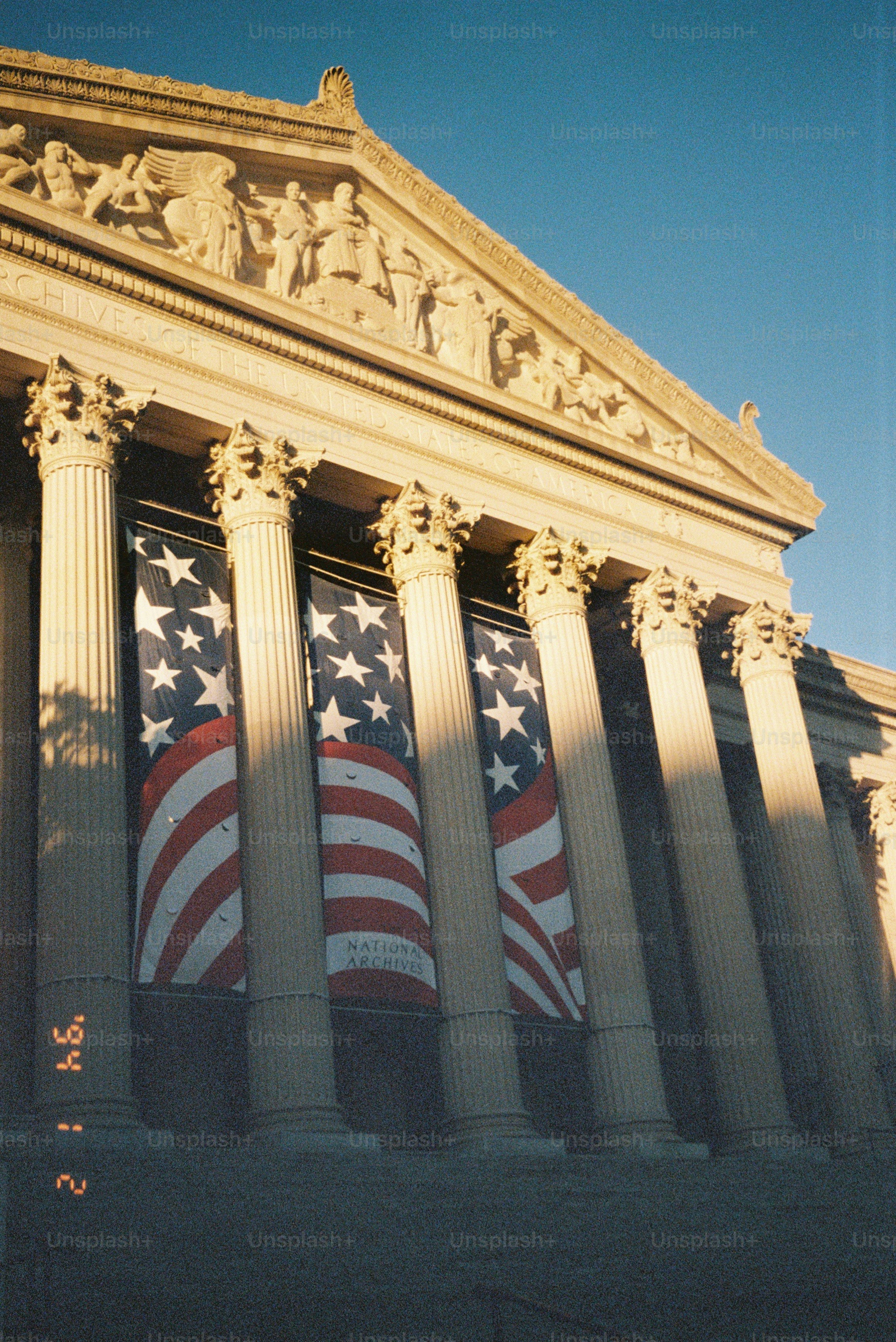 Banderas americanas colgadas en la fachada clásica del edificio con columnas