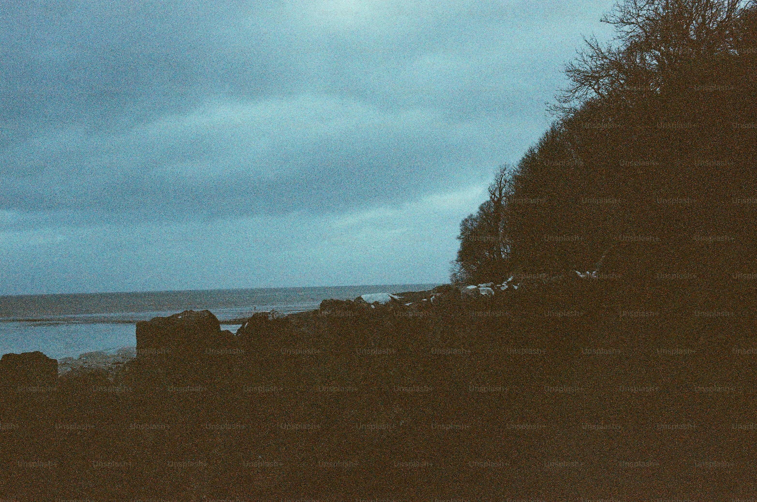 Düsterer bedeckter Himmel über einem ruhigen Gewässer.